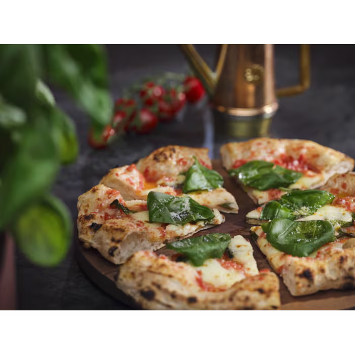 Paradicsomos, mozzarellás és bazsalikomos pizza fa tálon.