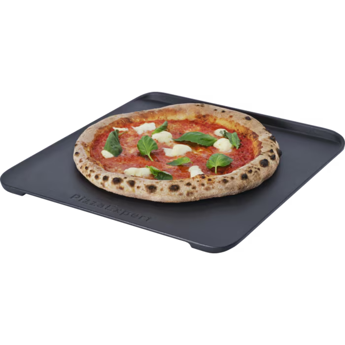 Egy Margherita pizza mozzarellával és bazsalikommal egy fekete pizzasütő lapon.