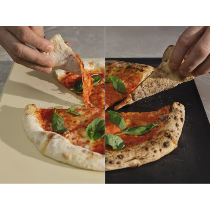 Paradicsomszószós és bazsalikomos pizza két fele, amelyeket kezek tartanak.