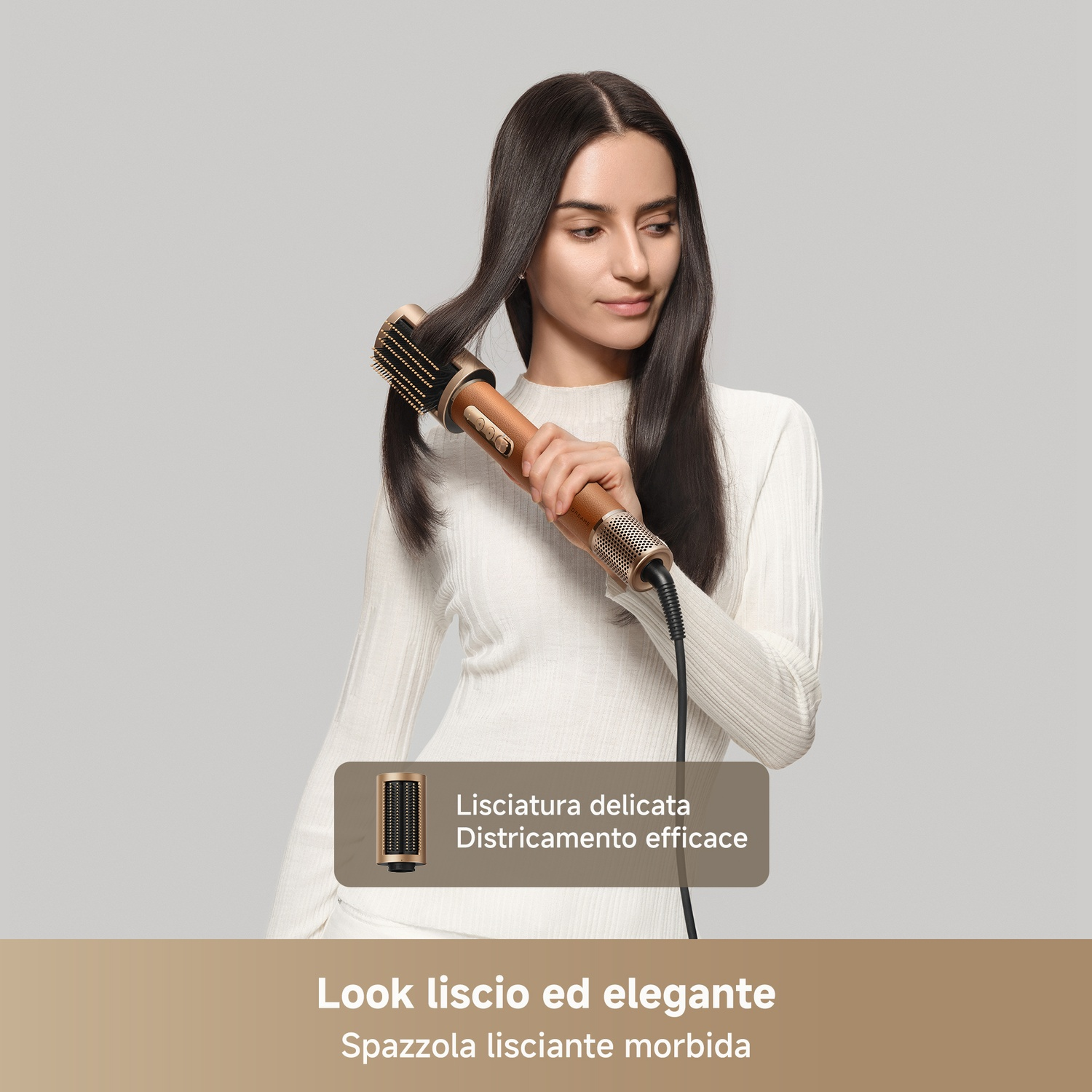 Una donna si acconcia i lunghi capelli scuri con un styler rotante dorato su sfondo grigio chiaro.