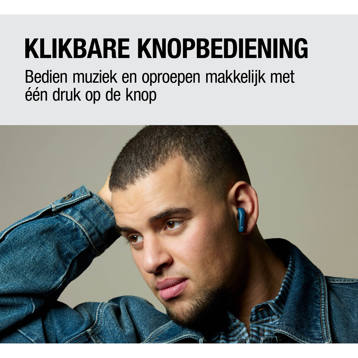 Man met blauwe oordop in zijn oor, draagt een spijkerjasje.