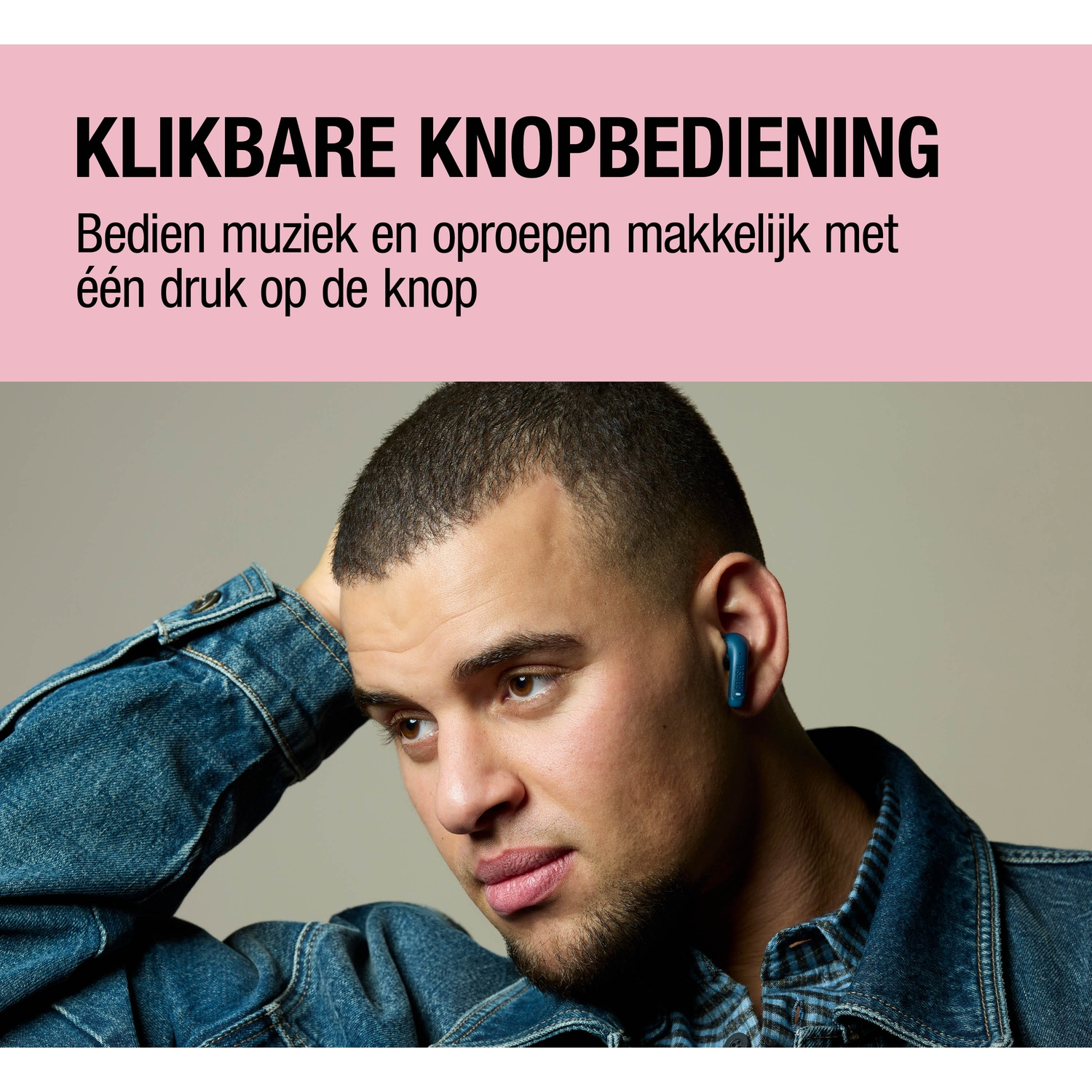 Man in blauwe spijkerjas en blauwe oordopjes, poserend met hand op hoofd.