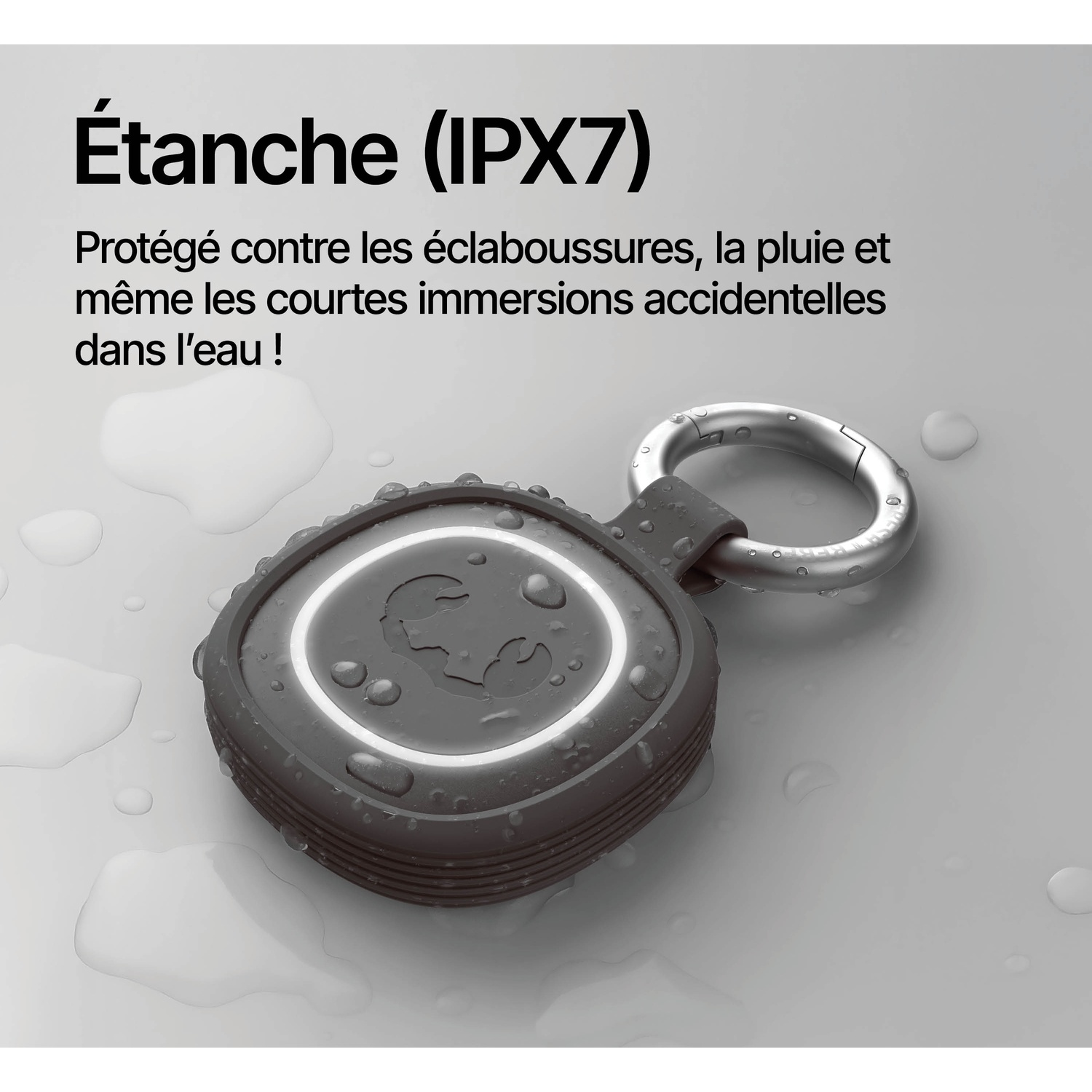 Haut-parleur gris étanche avec mousqueton et gouttelettes d'eau.