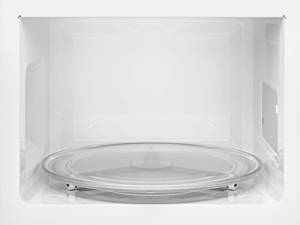 Vista interior de un microondas blanco con plato giratorio de cristal sobre base.