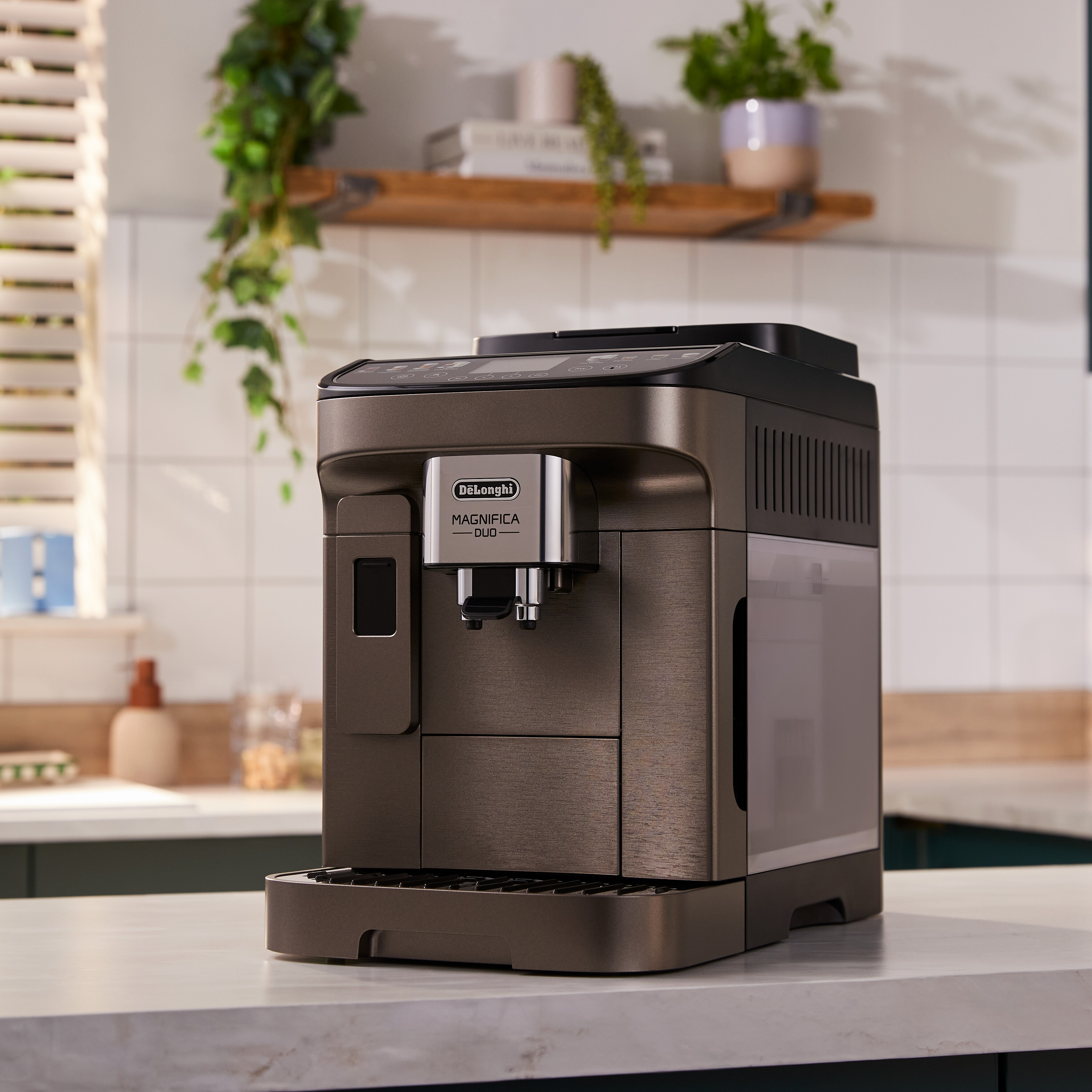 Eine dunkelgraue DeLonghi Magnifica Duo Kaffeemaschine steht auf einer Marmorarbeitsplatte.