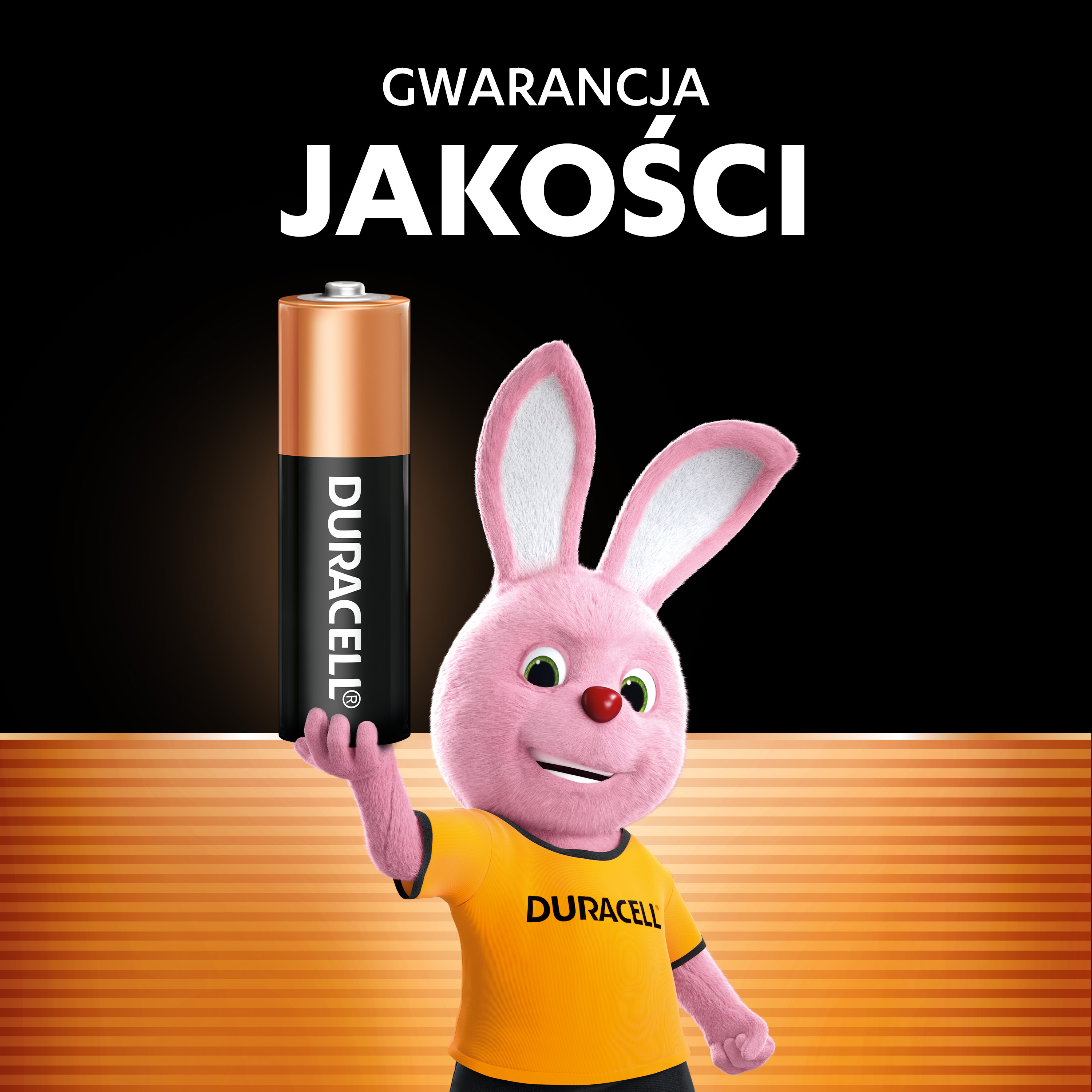 Różowy króliczek trzyma baterię Duracell na czarnym tle.