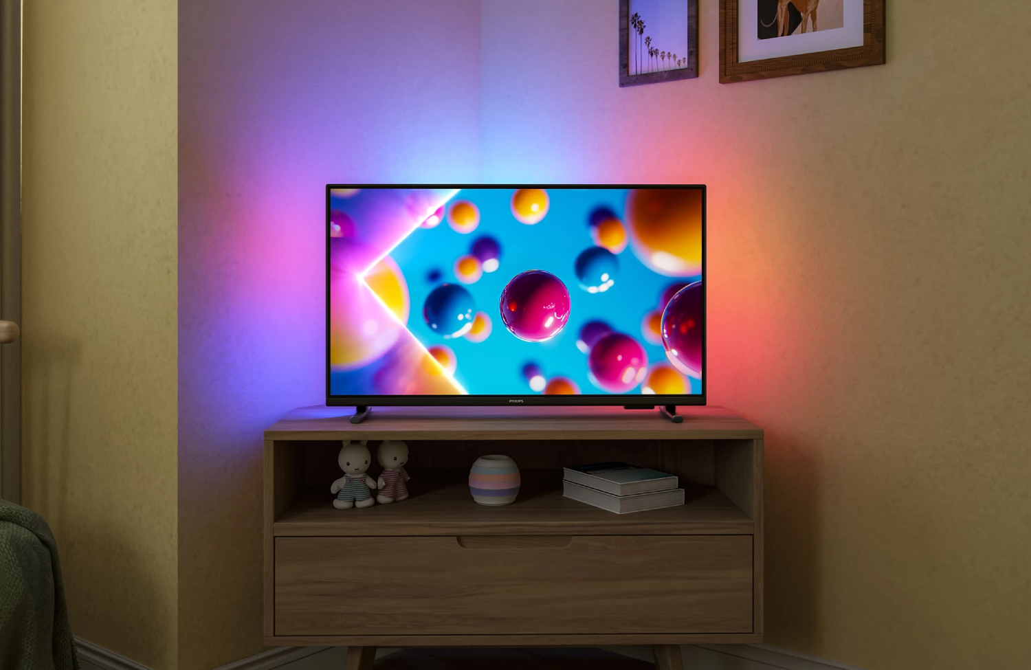 Un televisor moderno está sobre un mueble de madera, la pantalla muestra esferas coloridas.