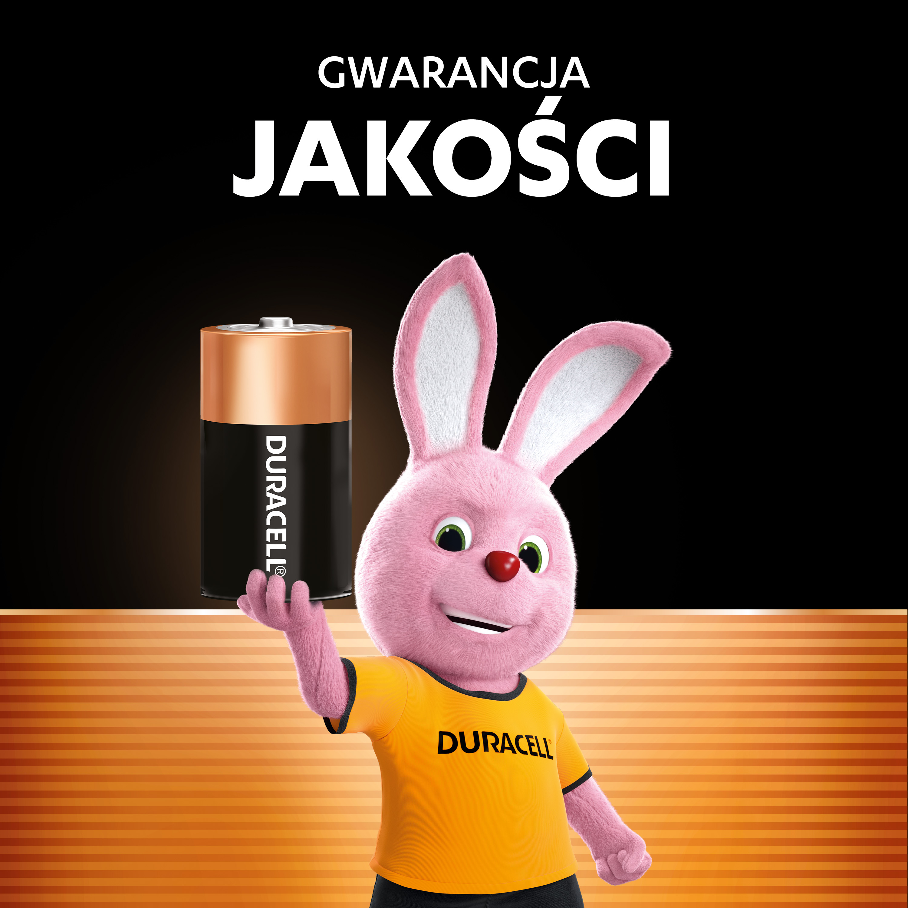 Różowy króliczek w koszulce Duracell trzyma baterię Duracell.