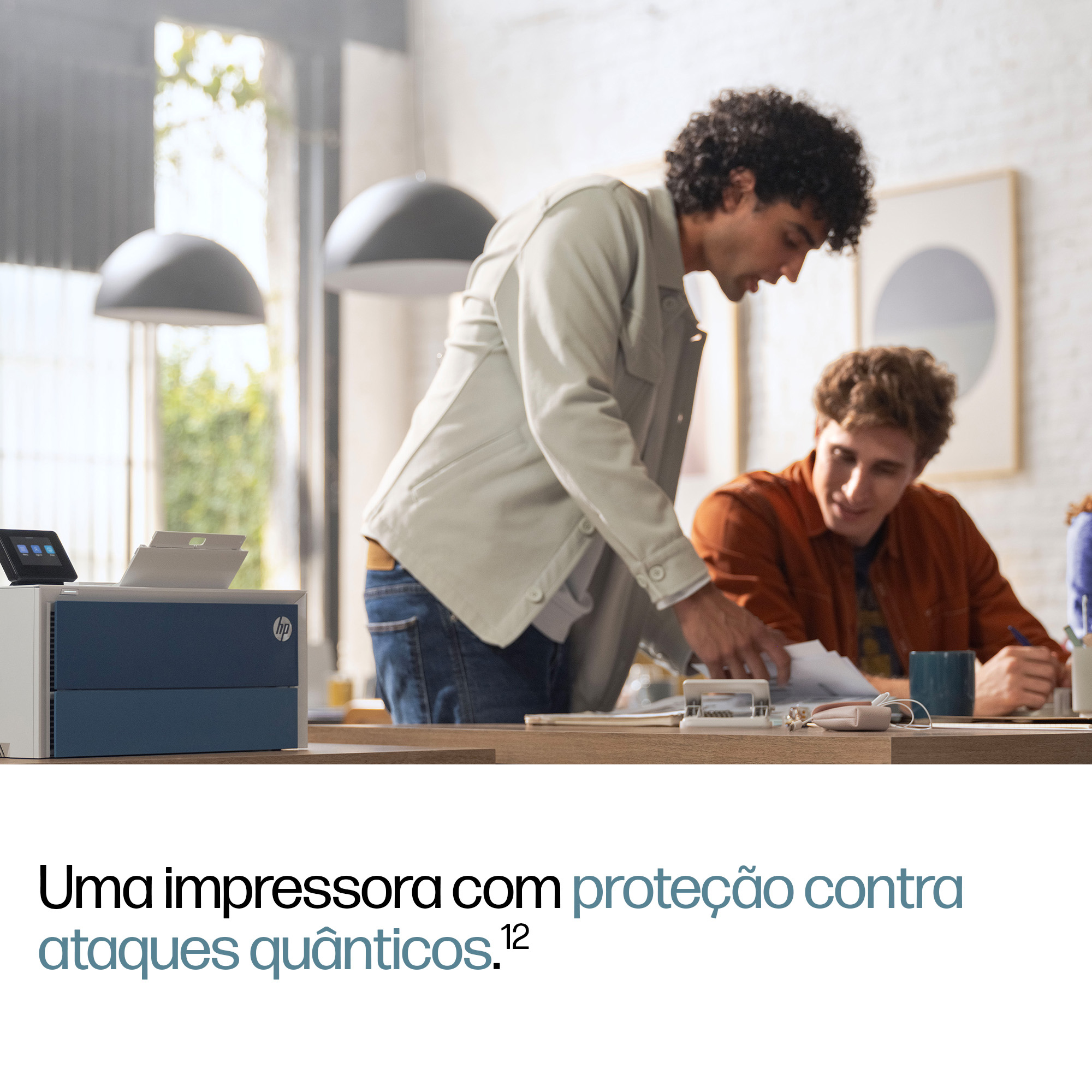 Dos hombres trabajan en un escritorio, con una impresora a la izquierda.