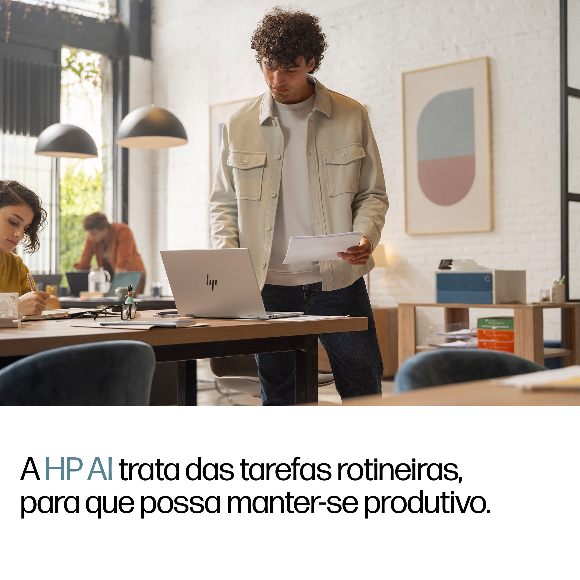 Hombres y mujeres trabajan en una oficina luminosa con portátiles y cuadernos.