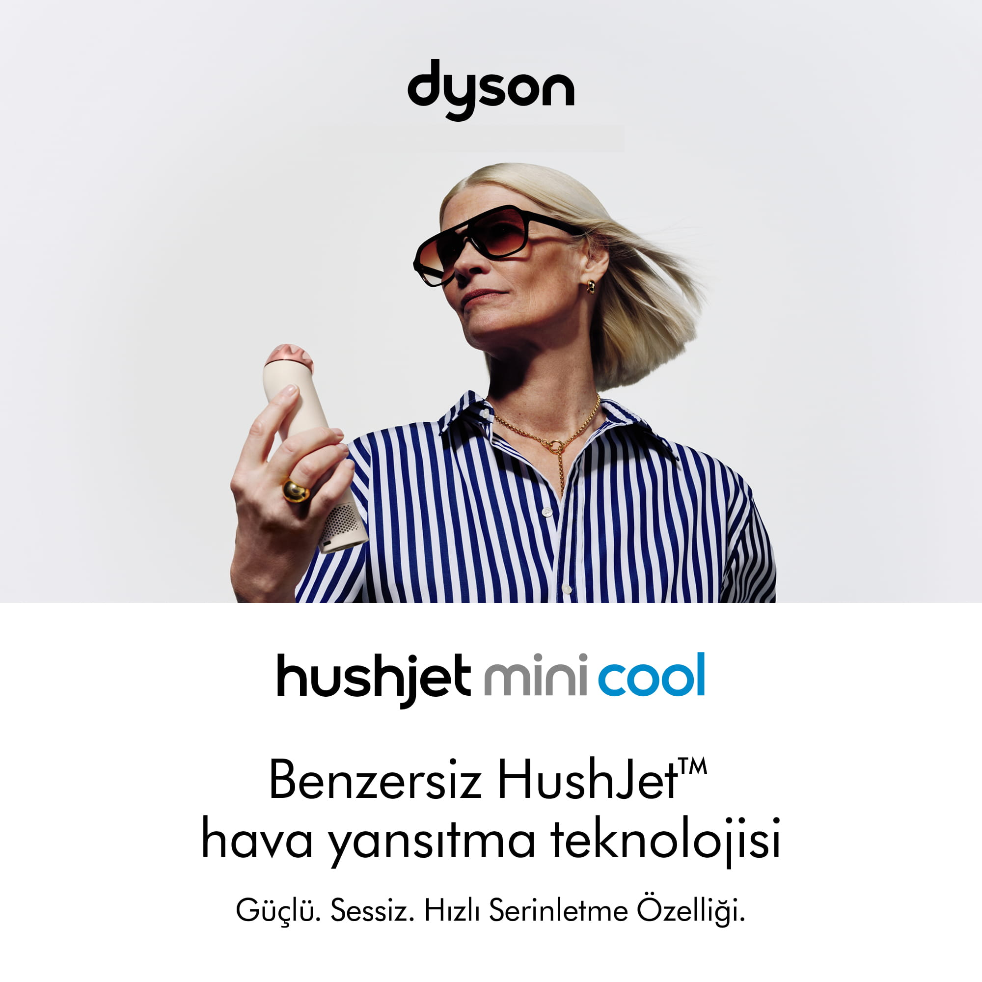 Güneş gözlüklü kadın Dyson HushJet Mini Cool cihazını beyaz fonda tutuyor.