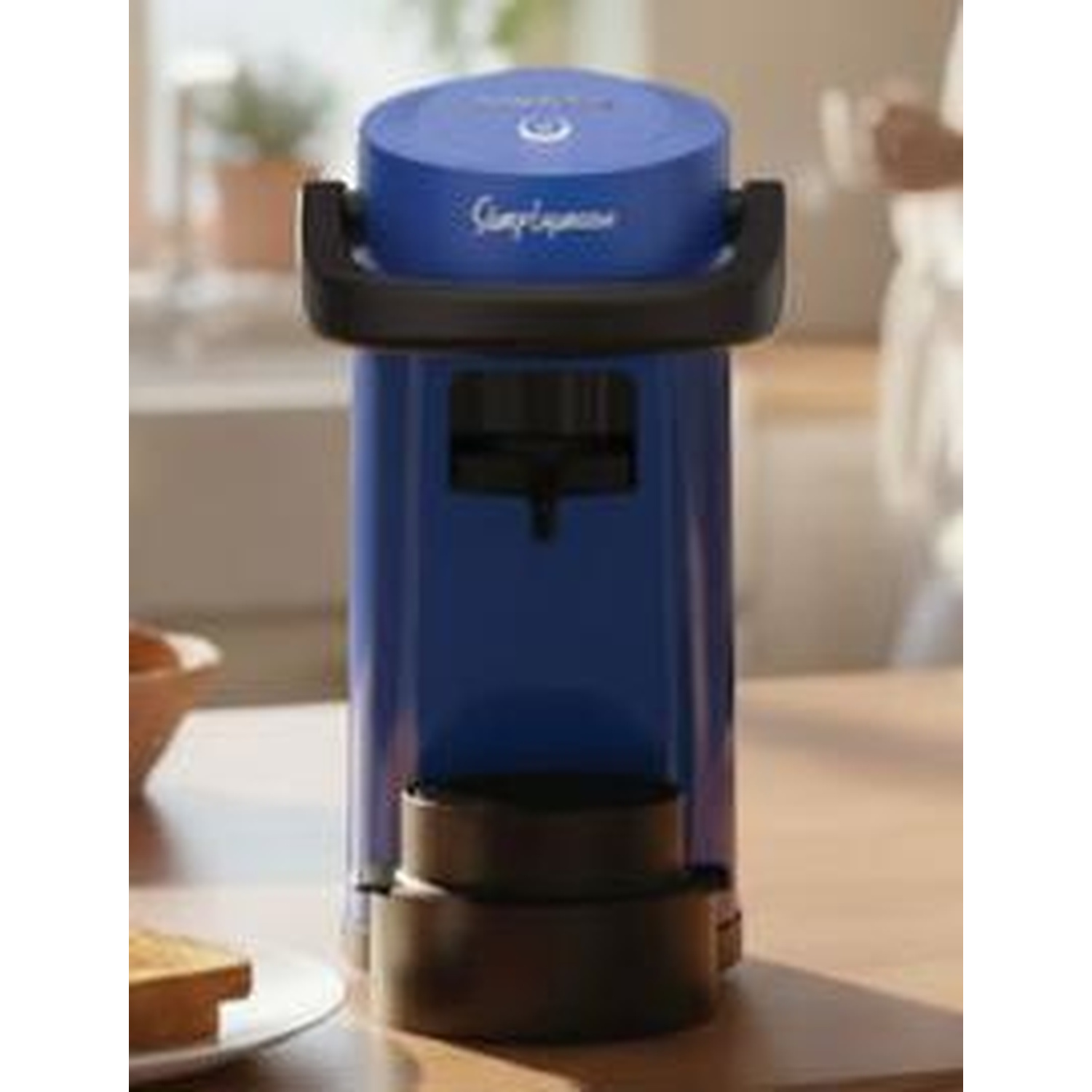 Macchina da caffè blu con manico nero su un tavolo di legno.
