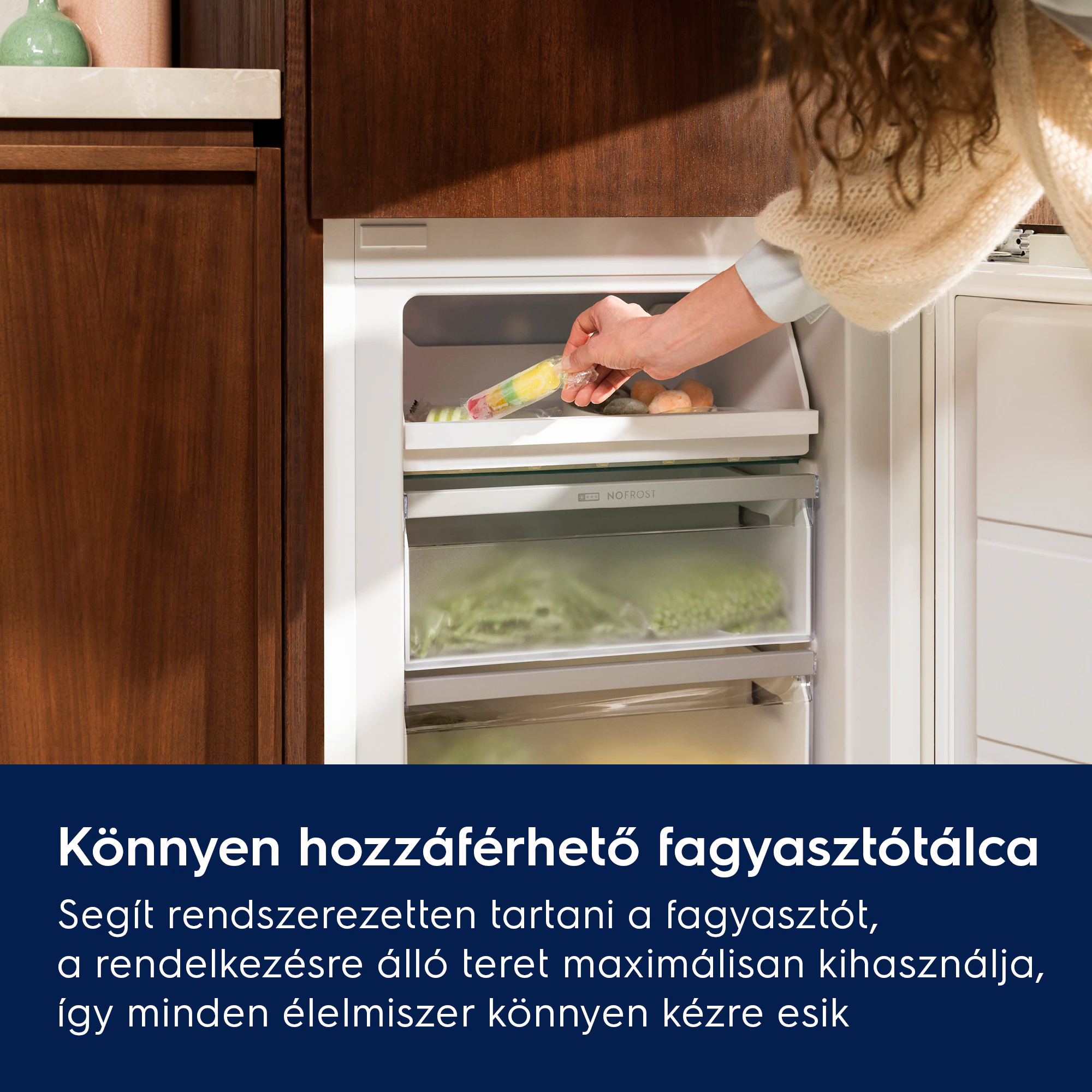 Kéz fagylaltot tesz a fagyasztó fiókjába, fagyasztott élelmiszerekkel.