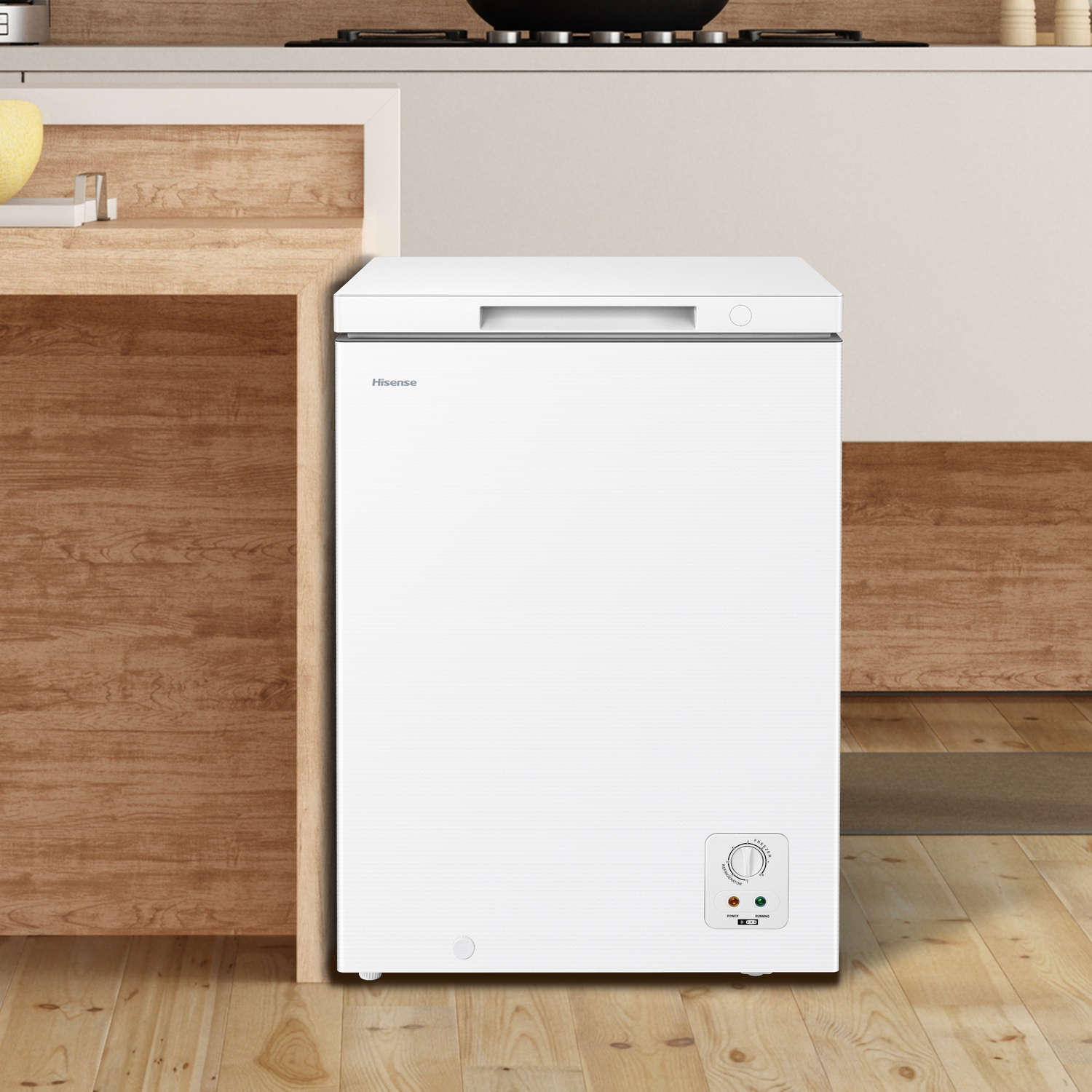 Un congelatore a pozzetto Hisense bianco è su un pavimento di legno accanto a un bancone di legno.