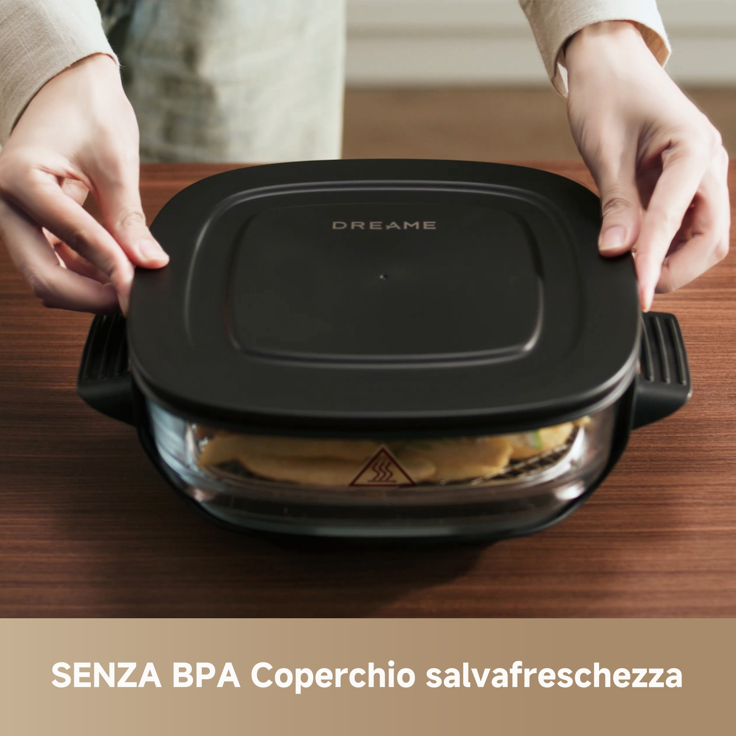 Mani che chiudono un coperchio nero su un piatto di vetro con cibo.