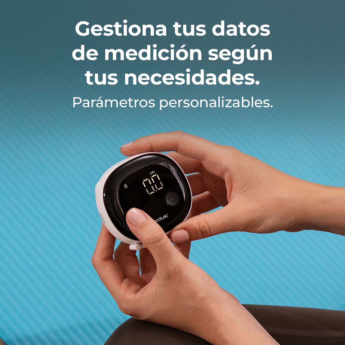 Manos sostienen un dispositivo de medición blanco con pantalla negra. Fondo azul.