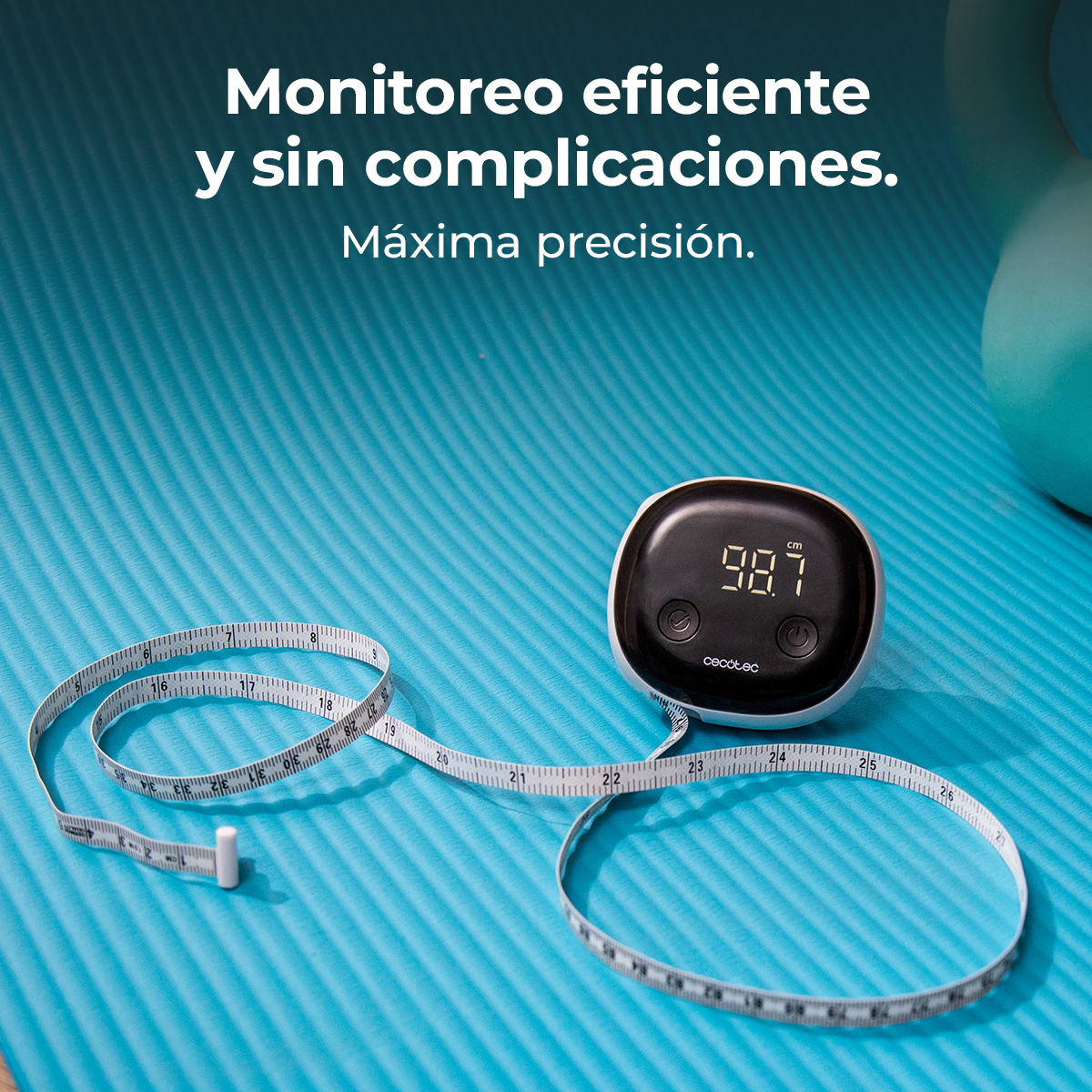 Una cinta métrica digital que muestra 98,7 cm y una pesa en una alfombra azul.