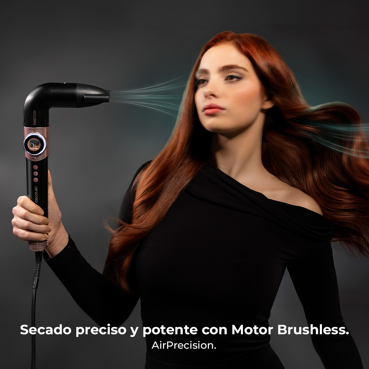 Mujer de pelo largo y rojo secándose el pelo con un secador negro y oro rosa.