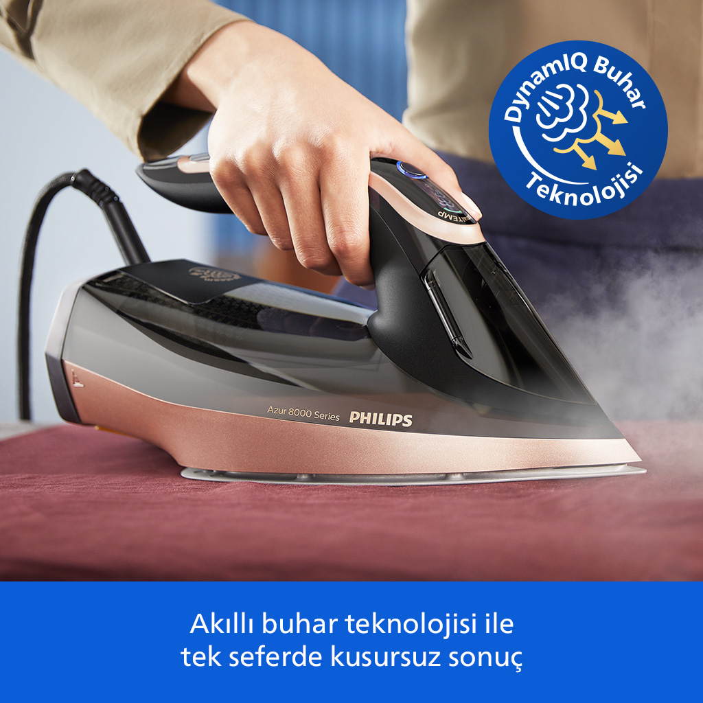 Bir el, kırmızı bir kumaşa buhar püskürten Philips ütü kullanıyor.