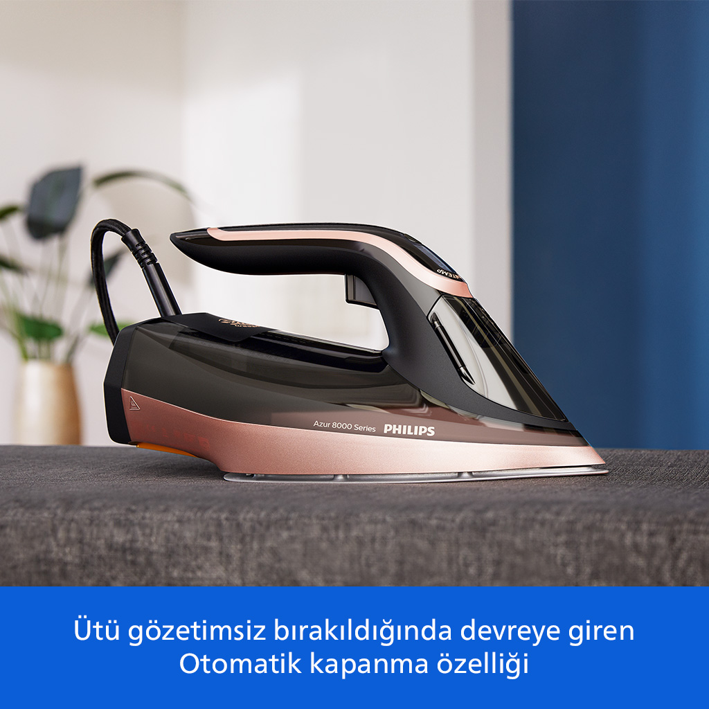 Gri kumaş üzerinde kulplu, roz altın rengi ve siyah buharlı ütü.