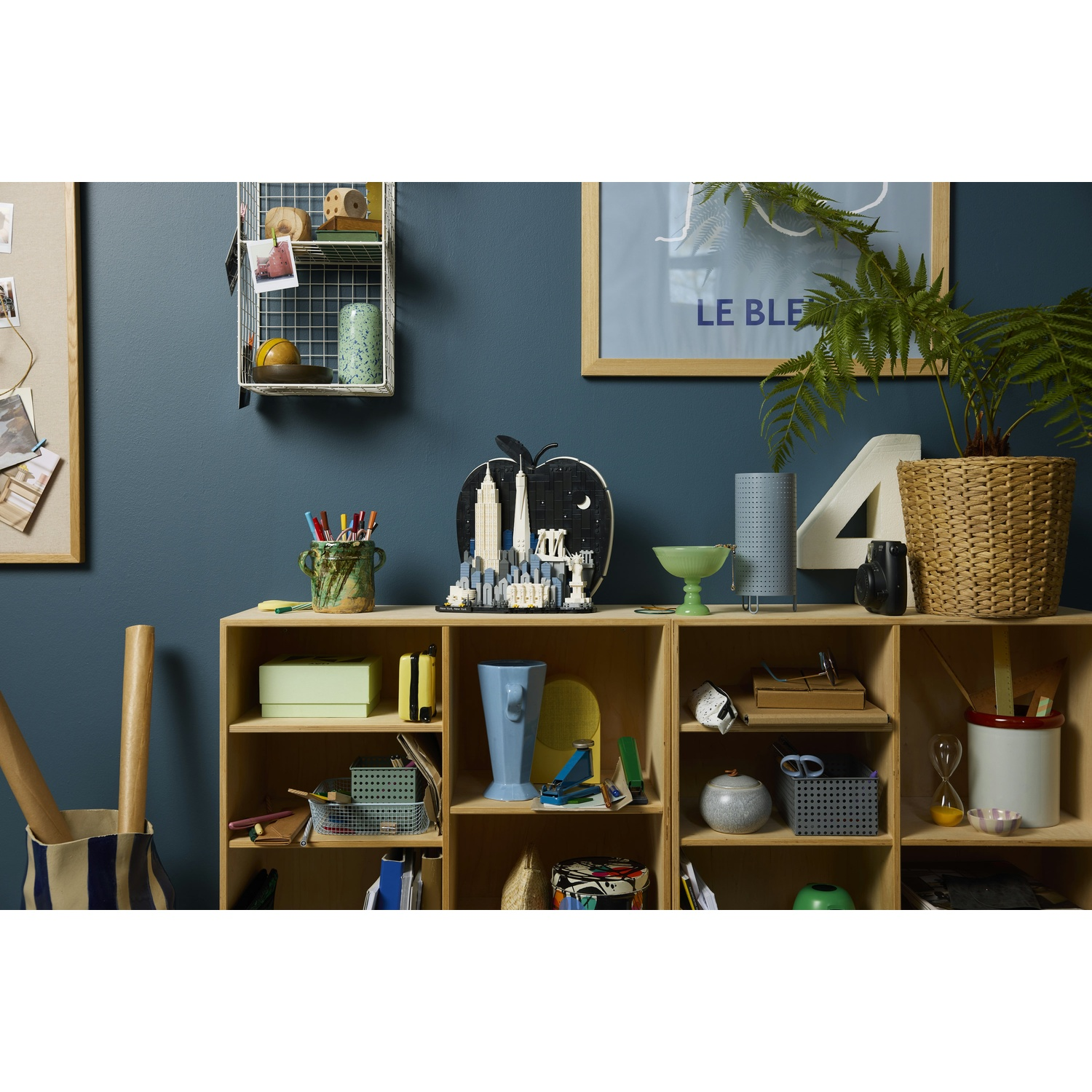 Un mobile a scaffali in legno pieno di vari oggetti decorativi e forniture per ufficio.