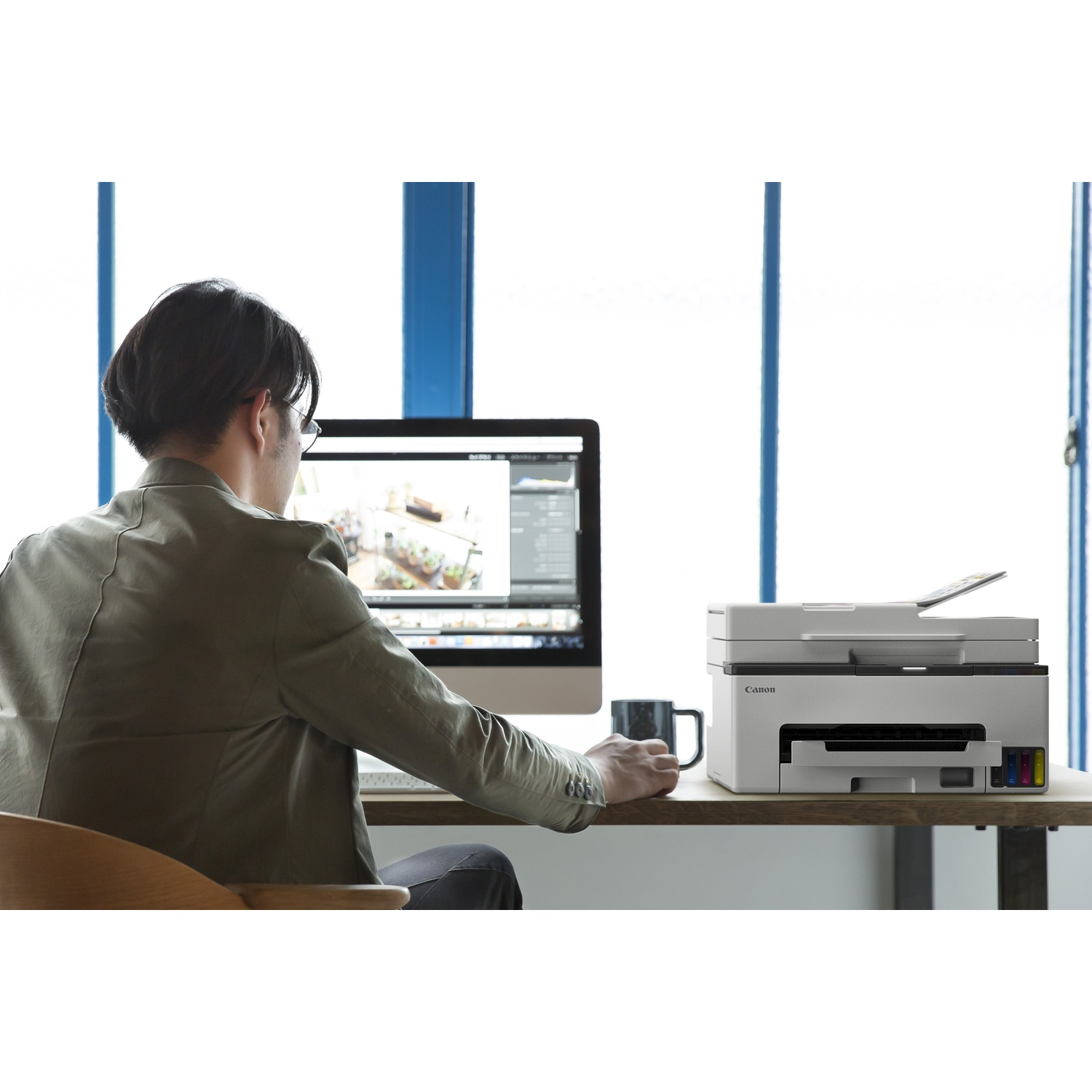 Man zit aan een bureau voor een computer en printer.