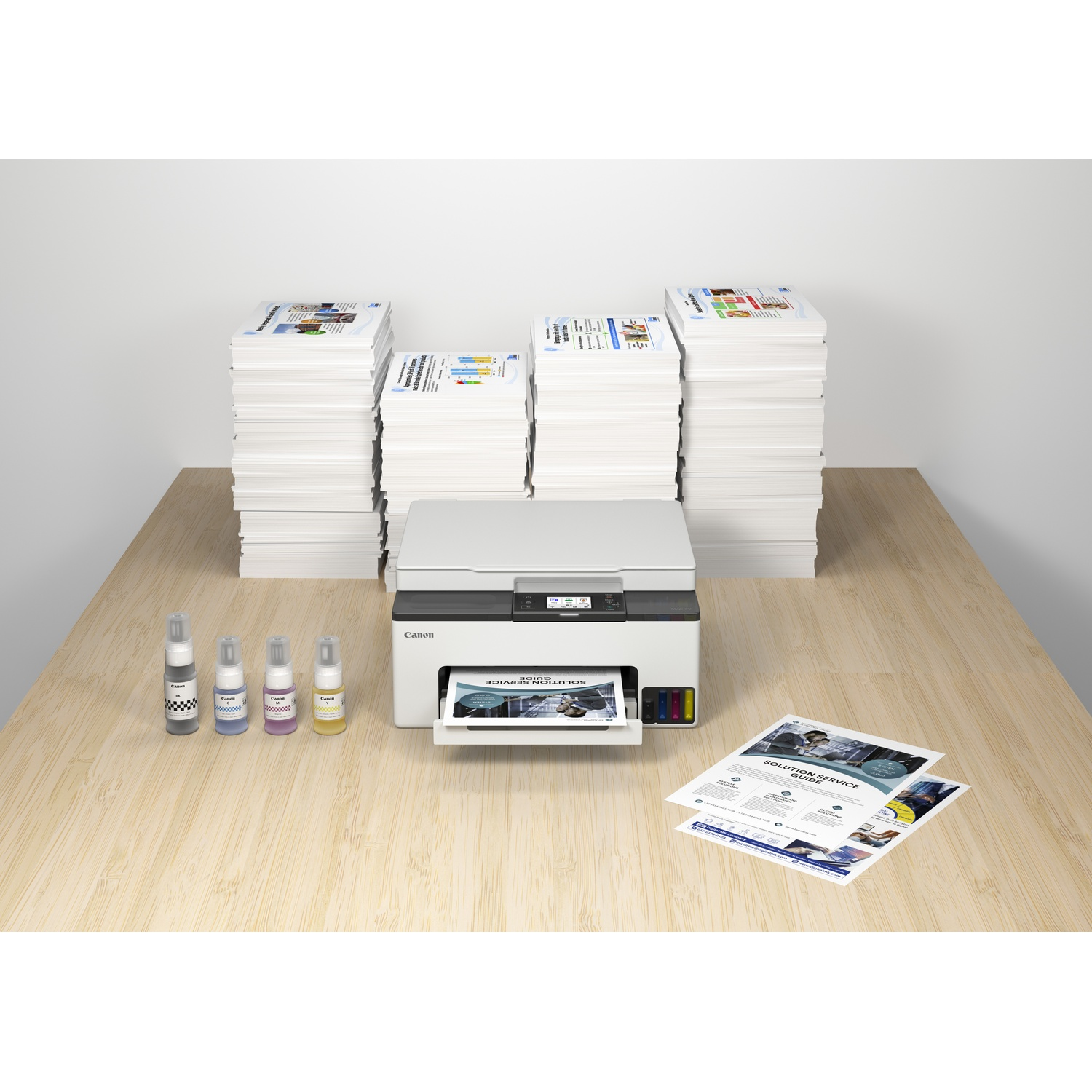 A white Canon printer sits on a wooden desk with stacks of paper and ink bottles.