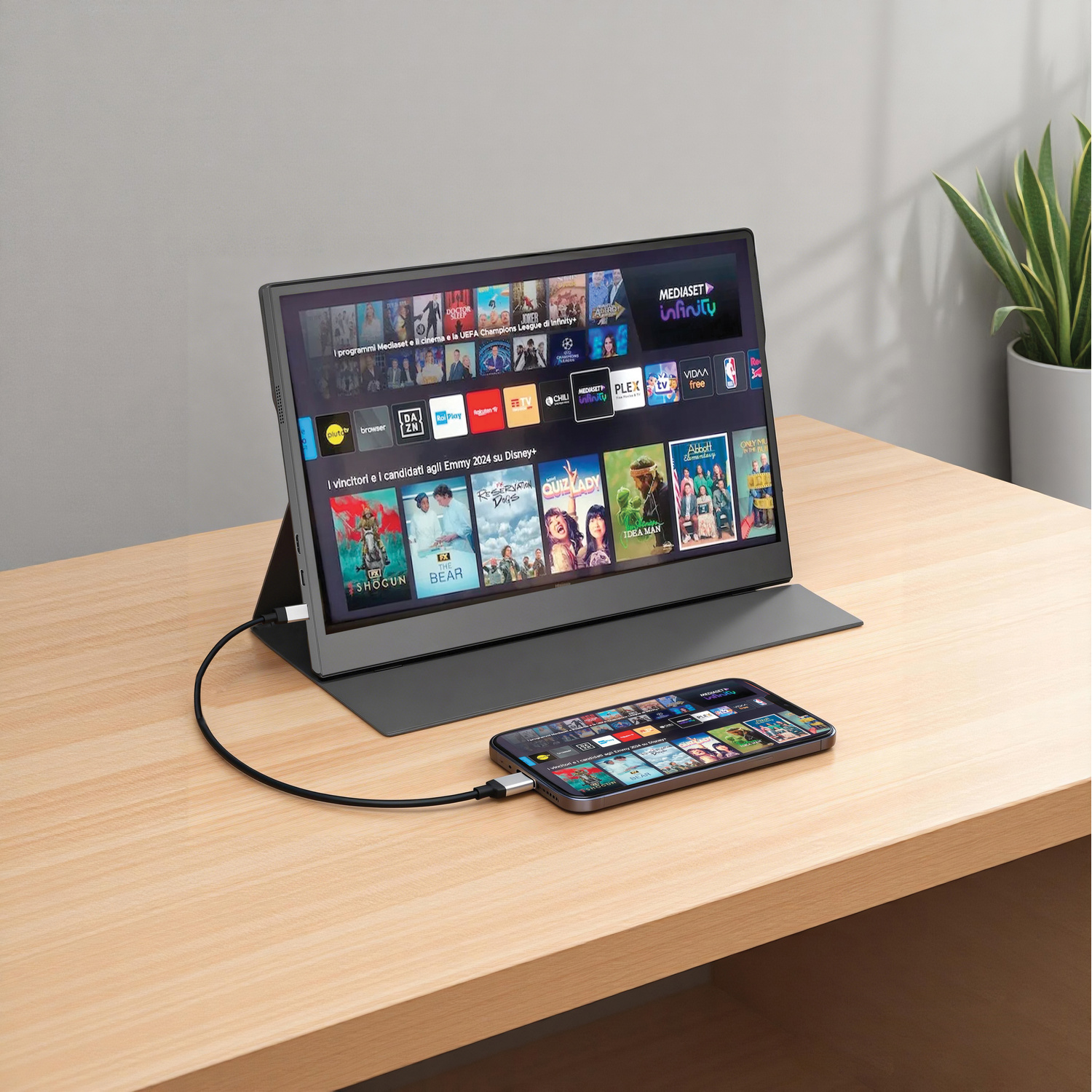 Un monitor portatile rispecchia lo schermo di uno smartphone, entrambi mostrano contenuti in streaming.