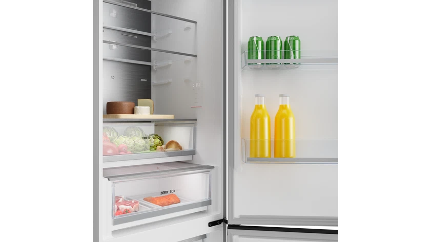 Un refrigerador abierto con productos, queso, carne y bebidas en los estantes.
