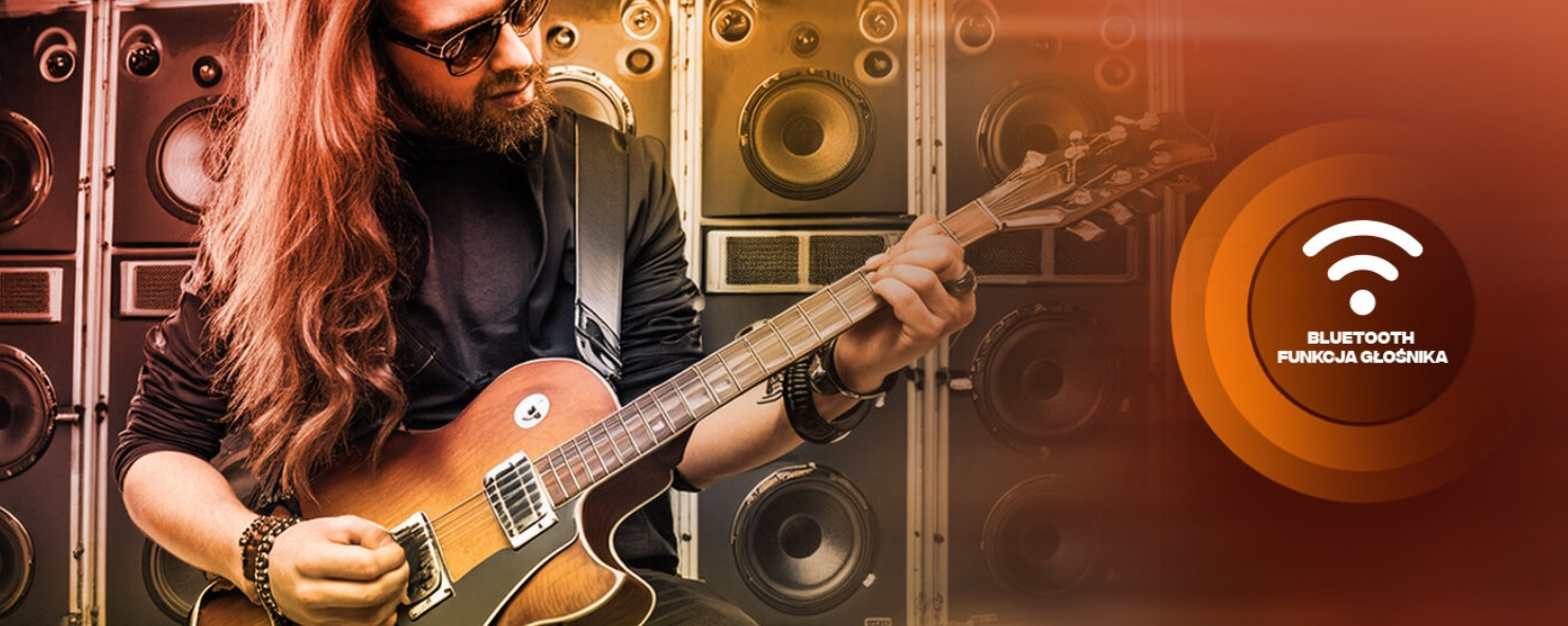 Mężczyzna z długimi włosami gra na gitarze elektrycznej przed stosami głośników. Symbol Bluetooth.