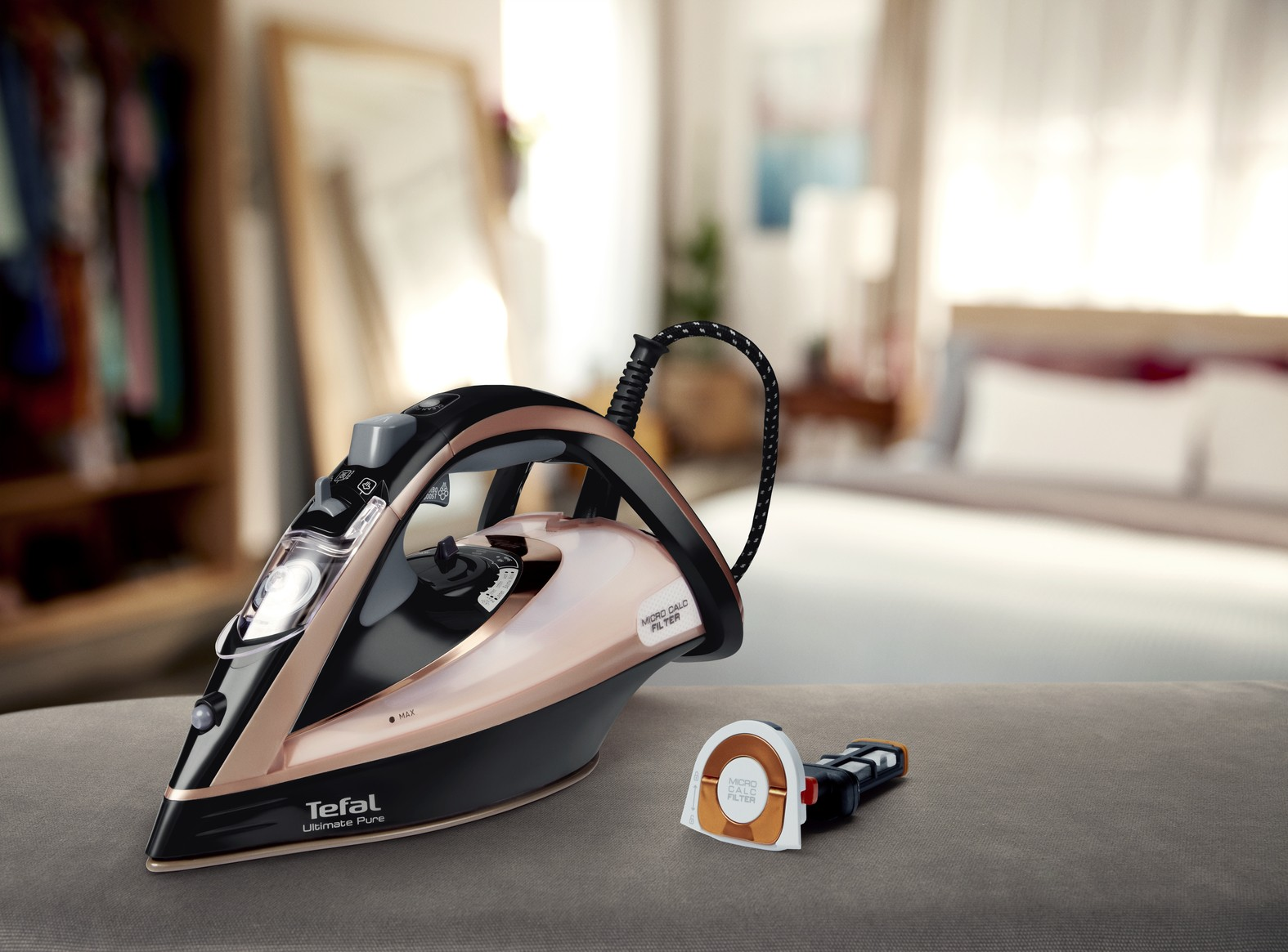 Żelazko Tefal z wyjmowanym filtrem antywapiennym leży na sofie.