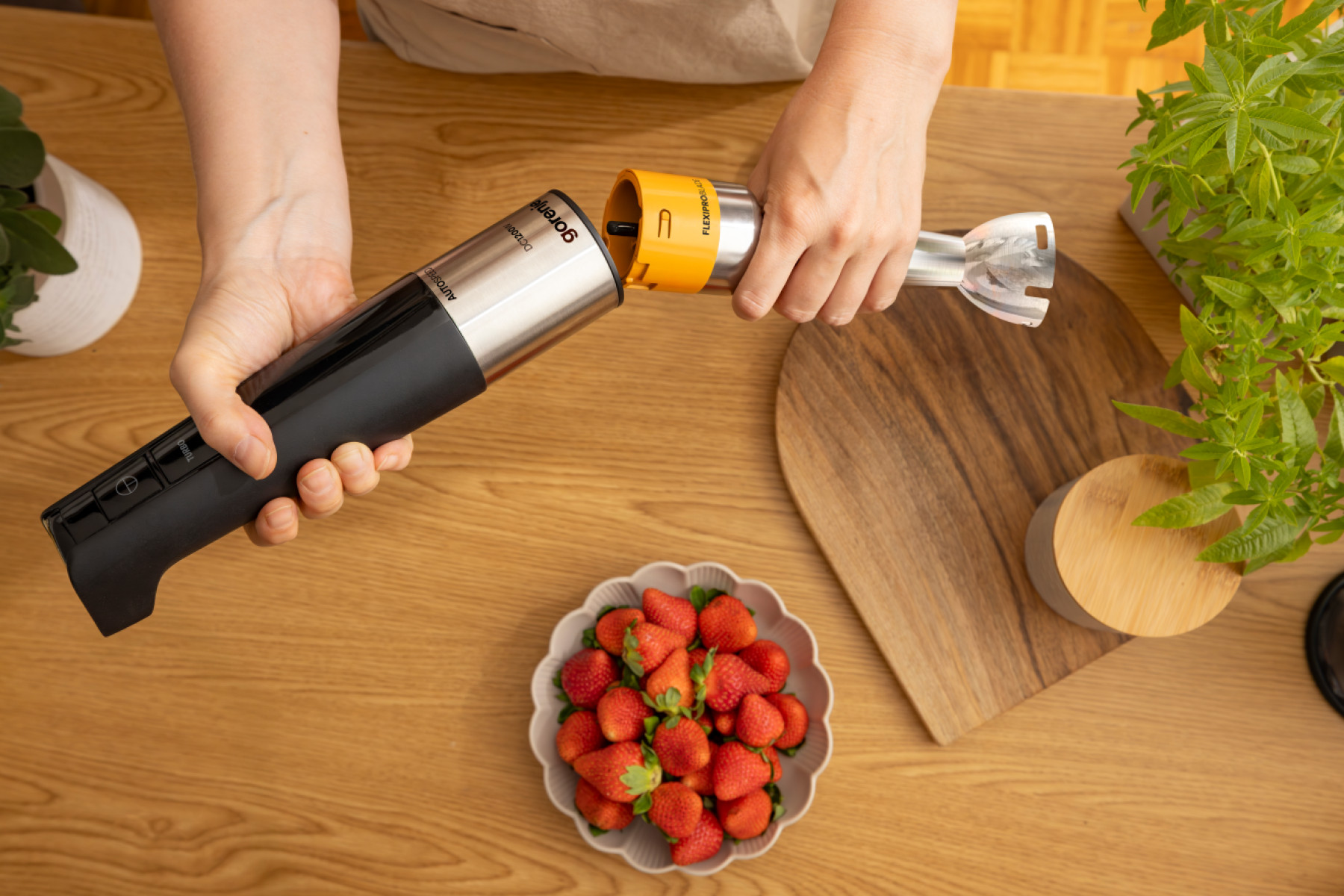 Dłoń trzyma blender ręczny ze srebrnym i czarnym uchwytem.