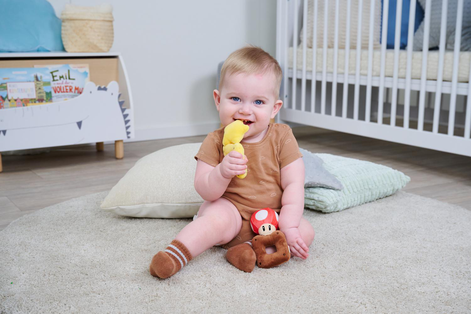 Ein Baby sitzt auf einem Teppich und spielt mit Spielzeug.