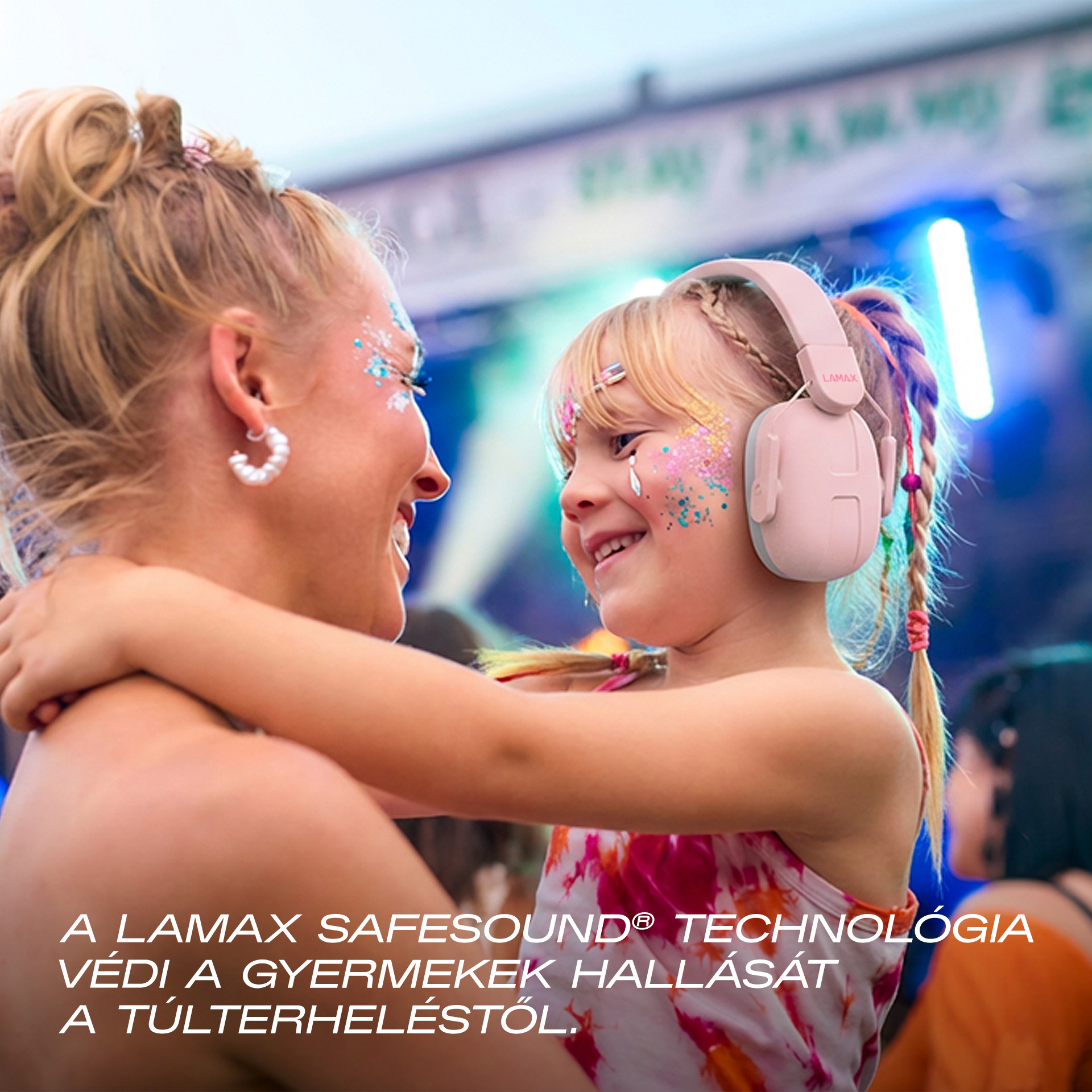 Nő és gyerek csillámmal az arcán és fejhallgatóval fesztiválon.