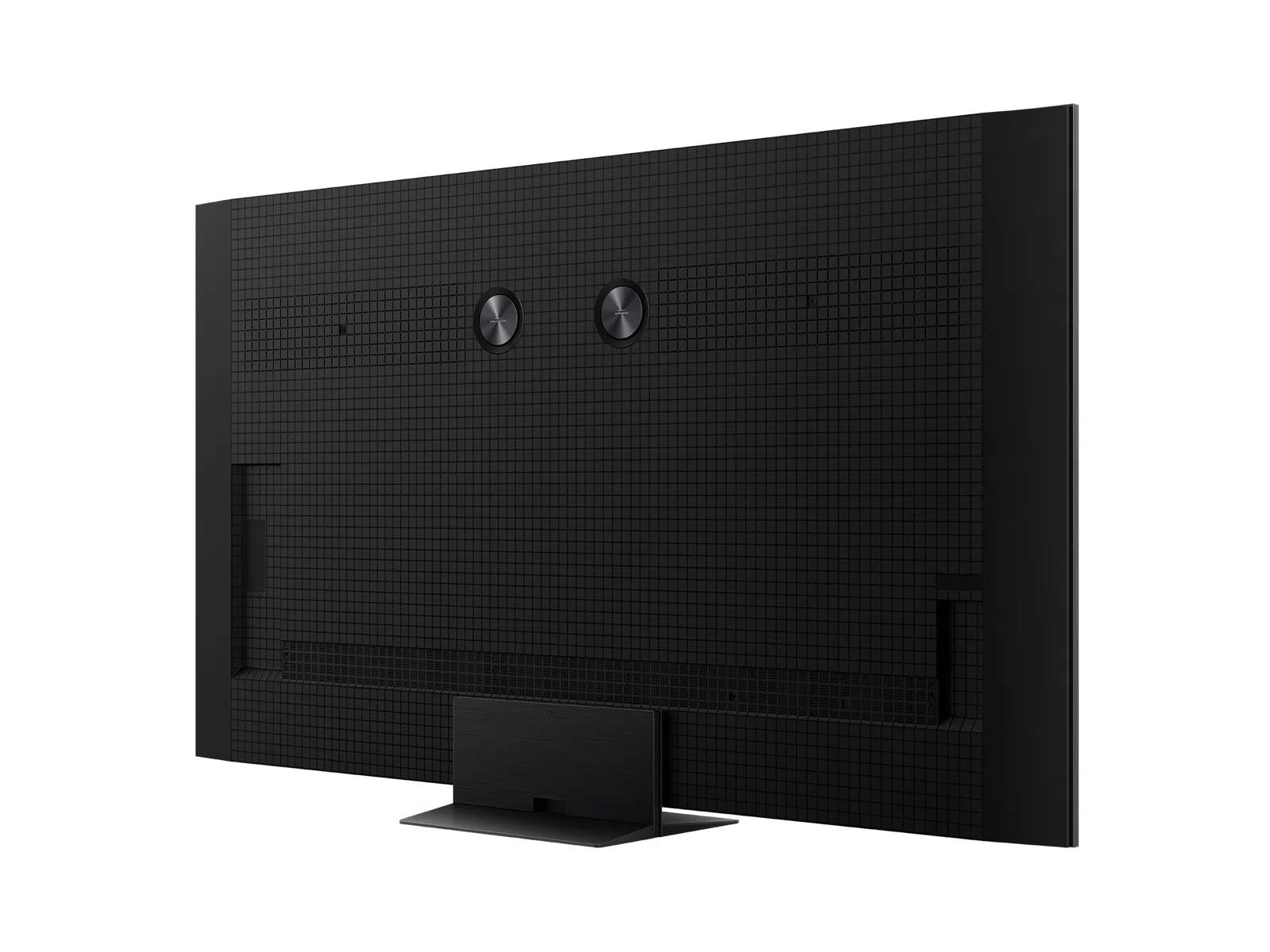 Parte trasera de un televisor negro con soporte. Patrón de rejilla cubre la parte trasera. Dos entradas circulares.