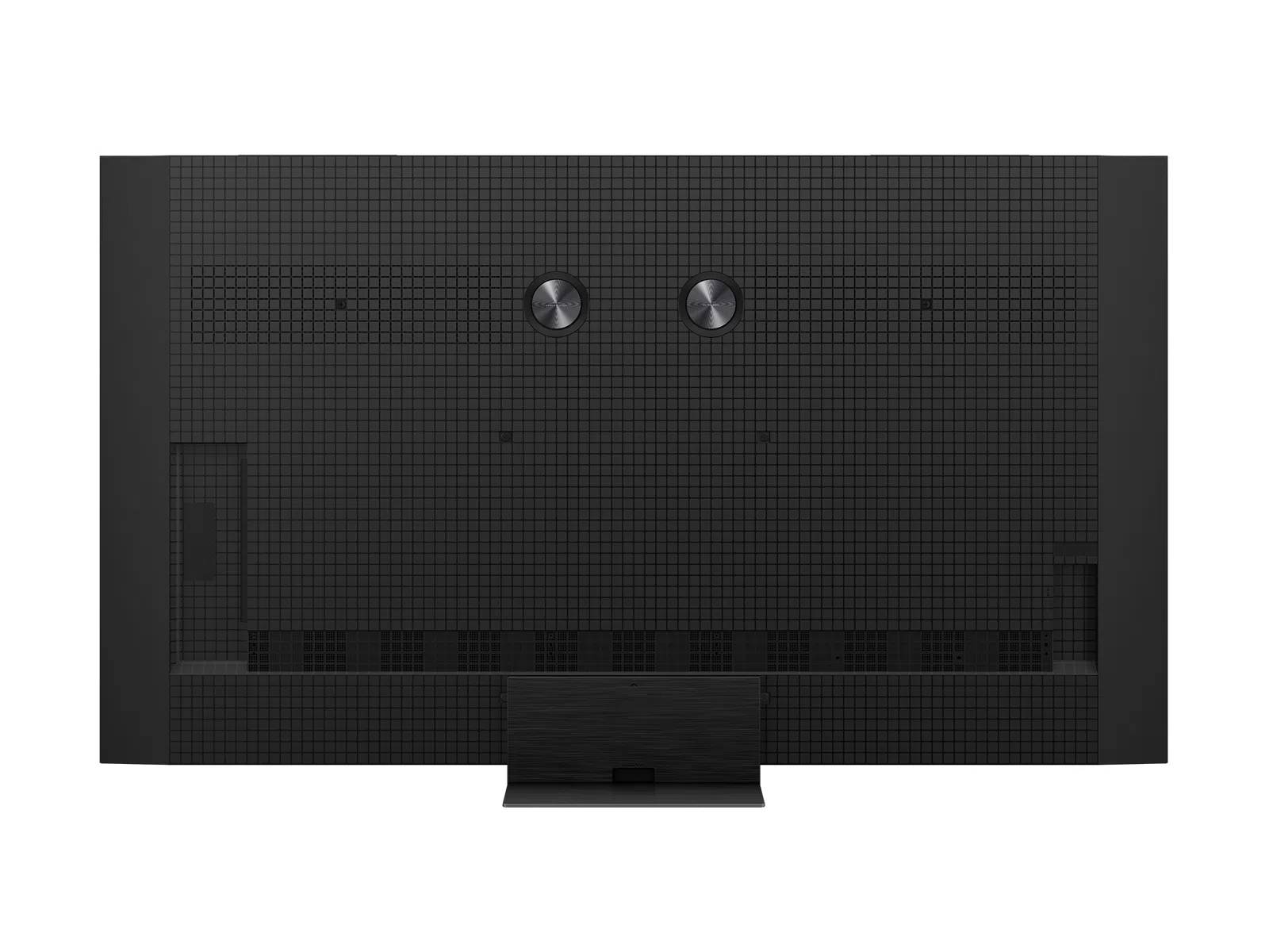 Parte trasera de un televisor negro con patrón de rejilla y dos botones redondos.