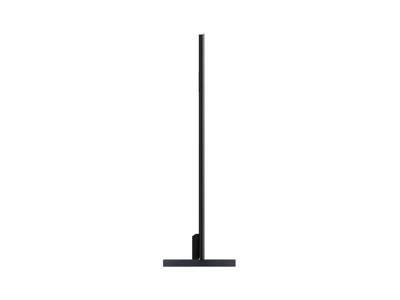 Un televisor negro está sobre un soporte estrecho sobre fondo blanco.