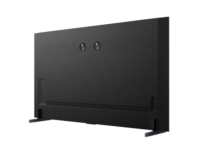 Parte trasera de un televisor negro con dos puertos redondos y dos soportes.