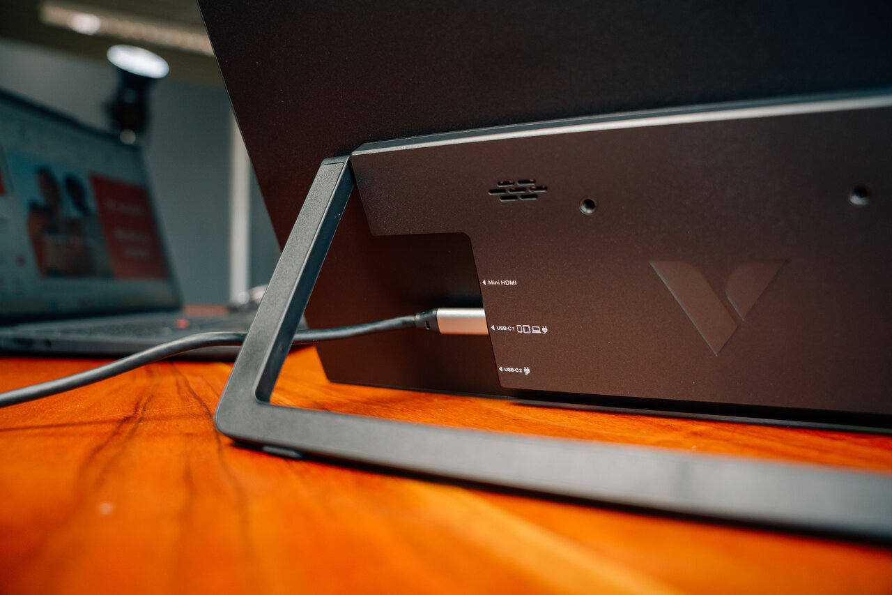 Supporto monitor nero collegato al laptop. Porte: Mini HDMI, USB-C.