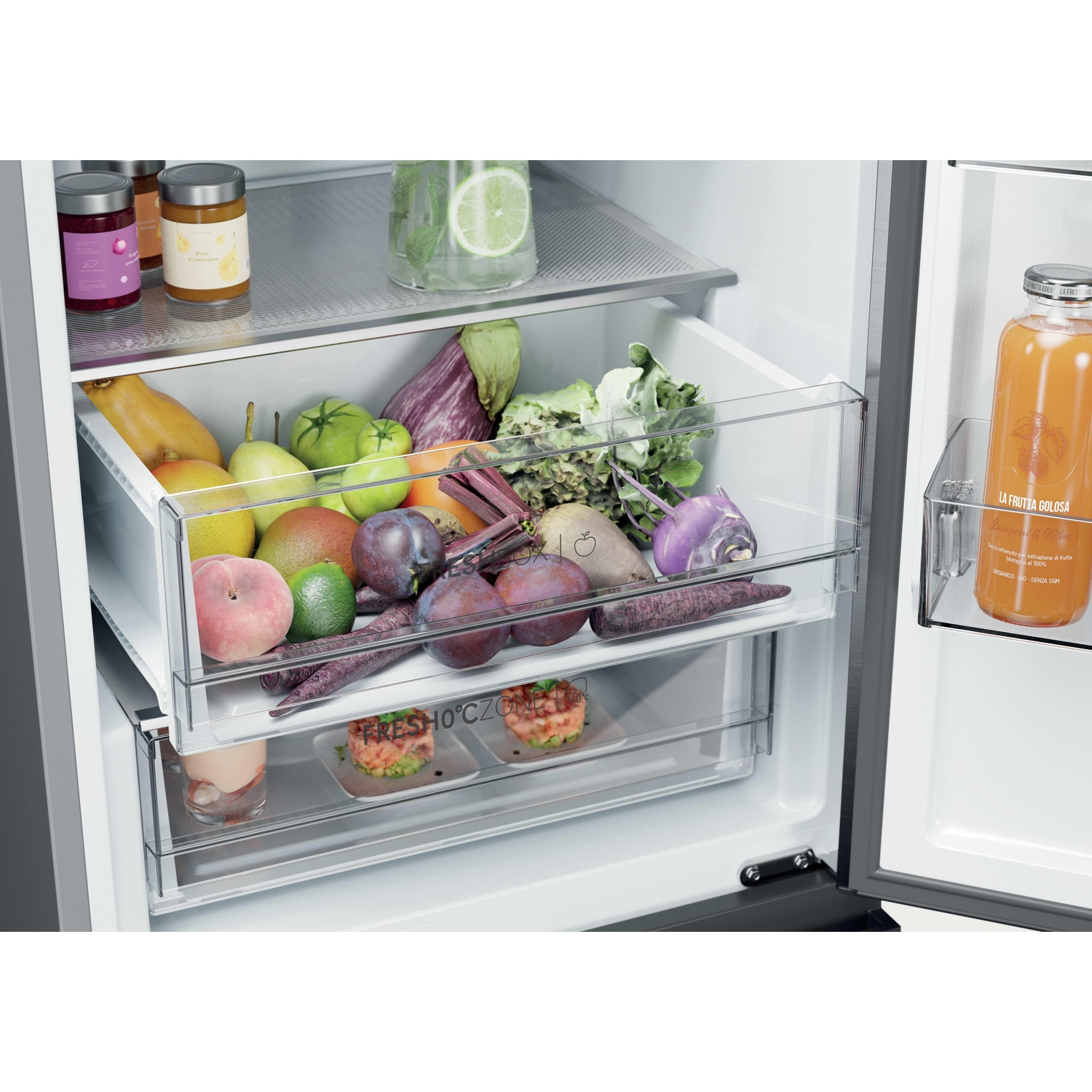 Interno frigorifero con frutta, verdura e bottiglia di succo.