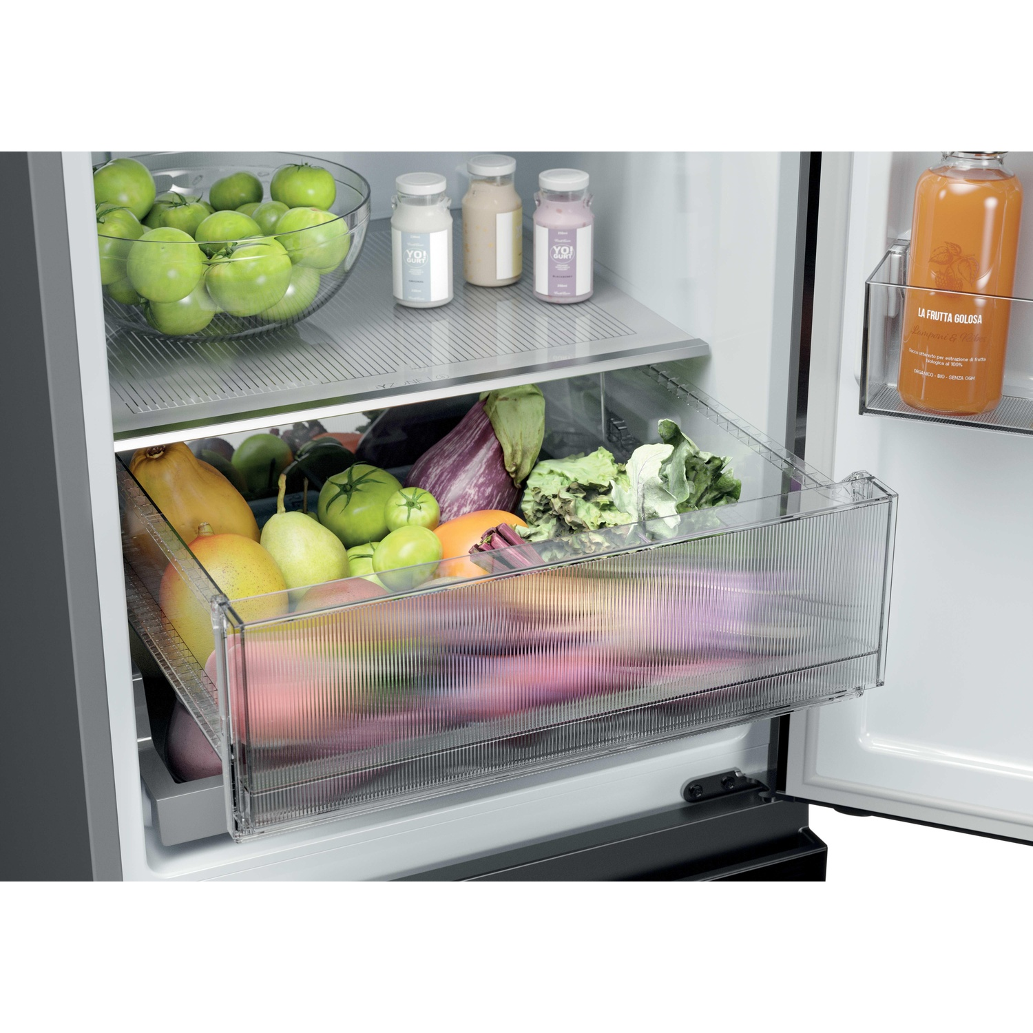 Interno del frigorifero con frutta e verdura in un cassetto e bottiglie.