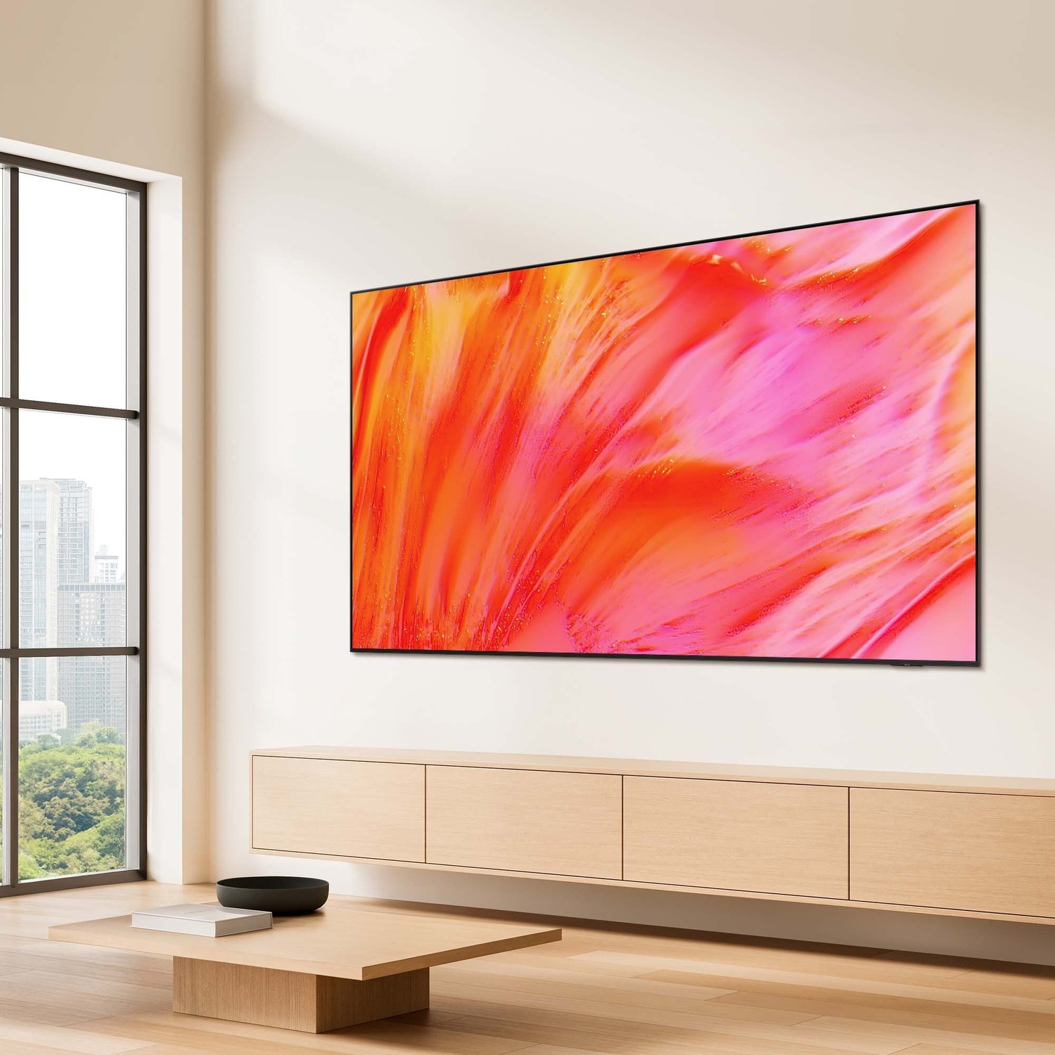 Una grande TV mostra arte astratta nei toni del rosa e dell'arancione. Un mobile in legno e un tavolino sono in primo piano.