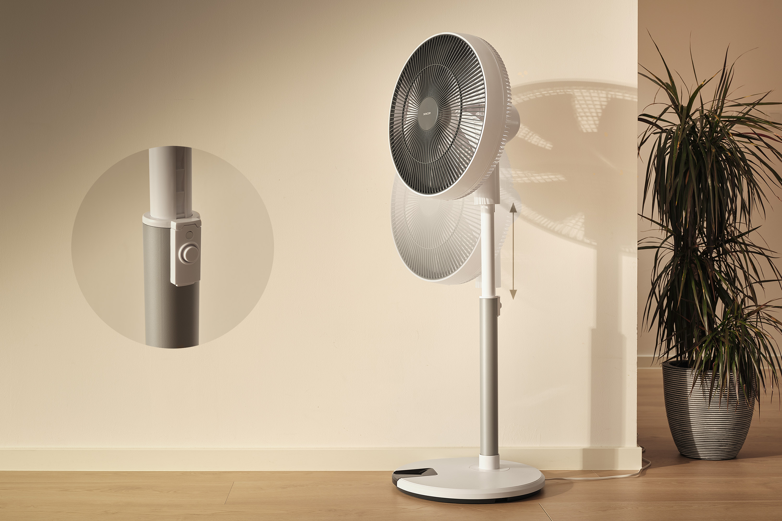 Egy fehér álló ventilátor szürke állvánnyal fa padlón áll.