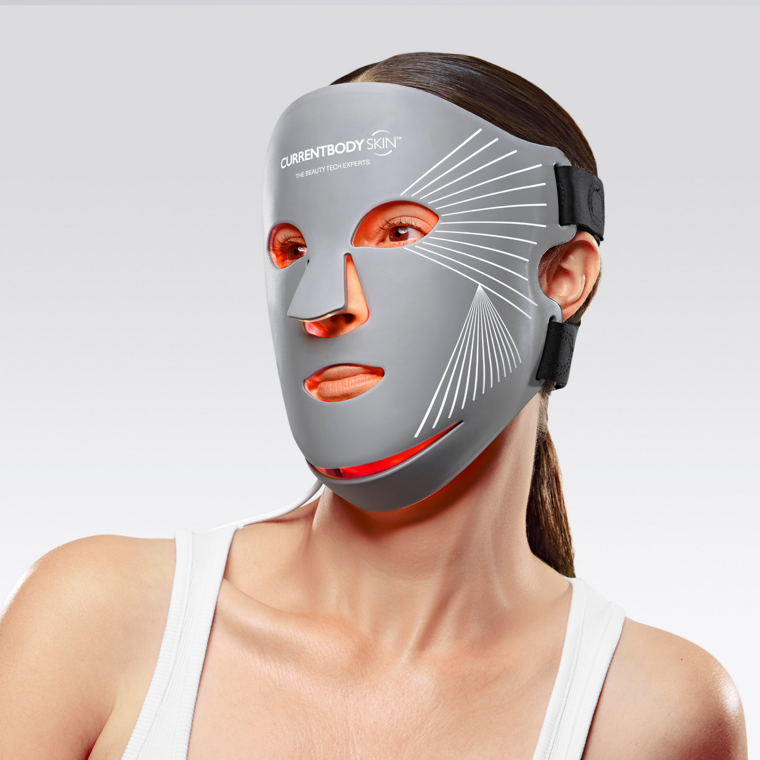 Una mujer lleva una mascarilla facial LED gris con luces rojas.