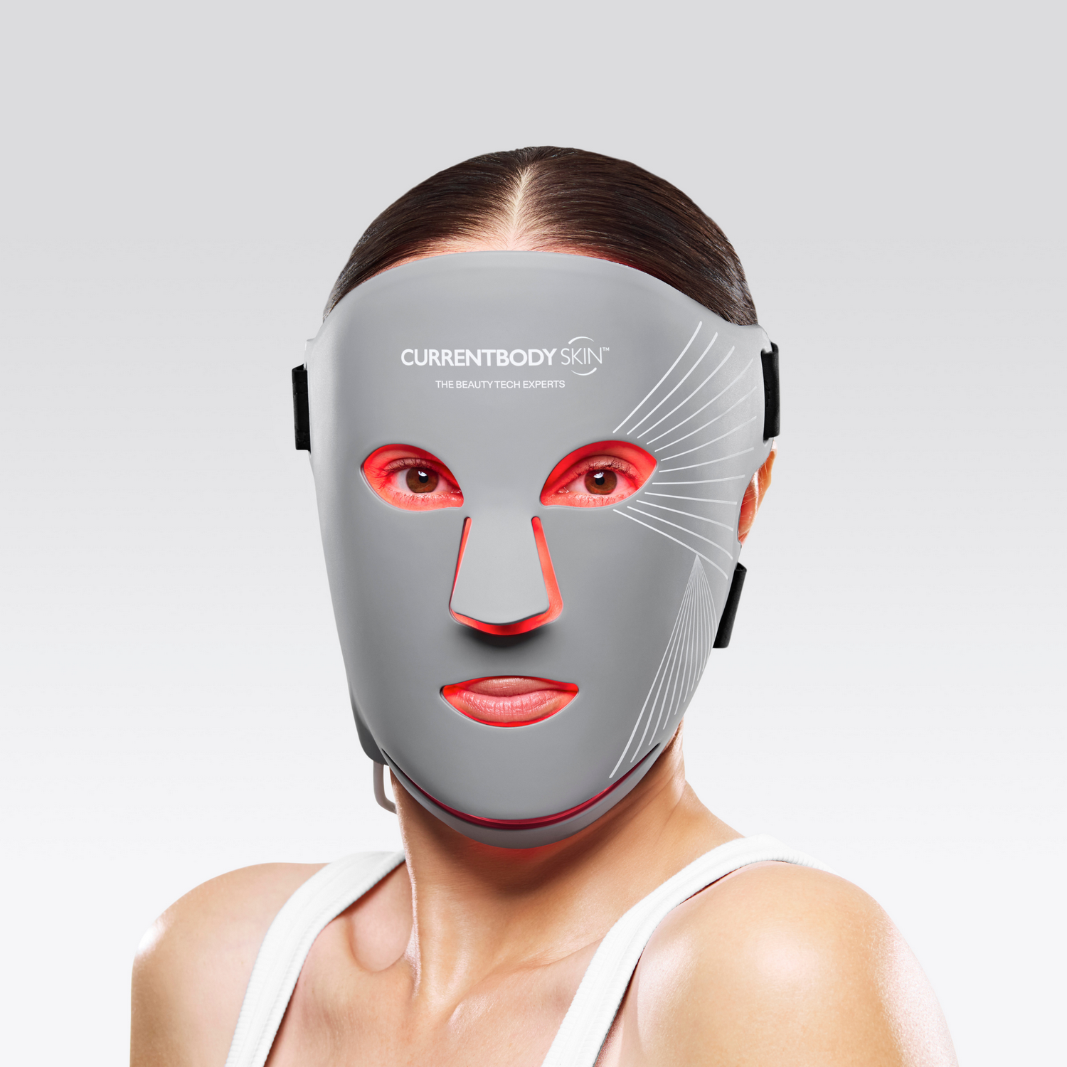 Una mujer usa una mascarilla gris con luces rojas en ojos y boca.