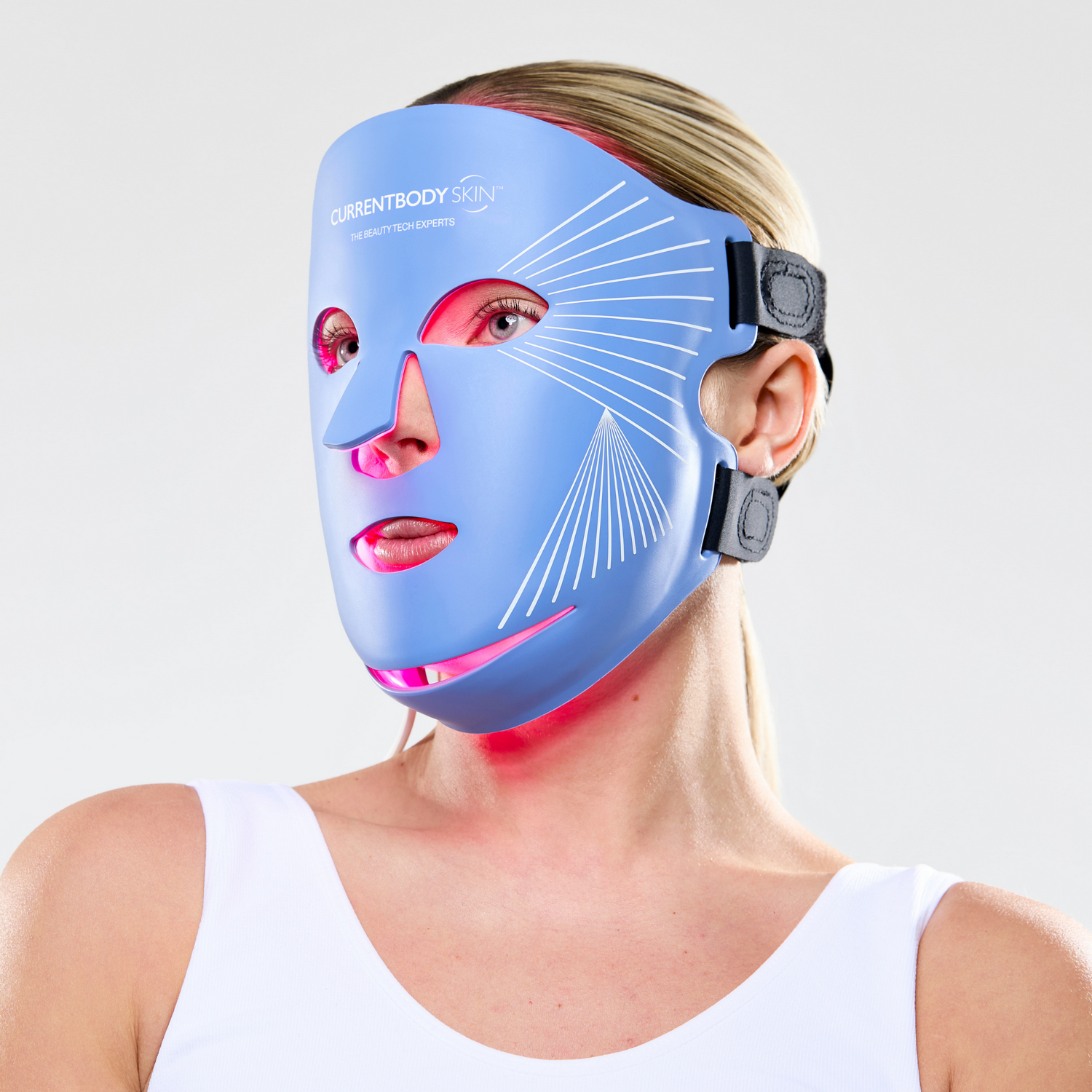 Mujer con mascarilla facial LED azul con luces rojas brillando en su cuello.