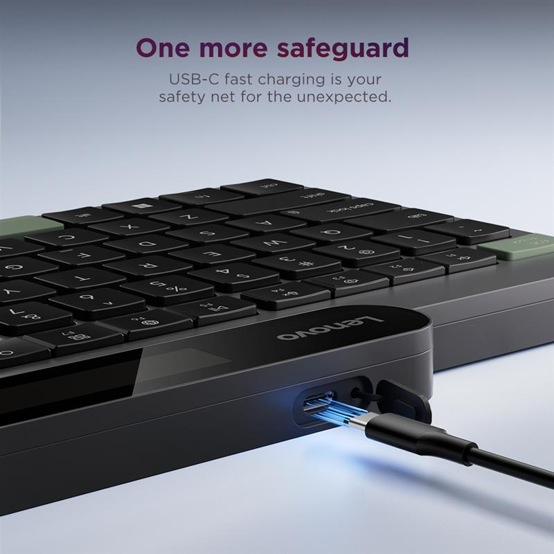 Un teclado Lenovo negro se carga por USB-C. Luces azules brillan.
