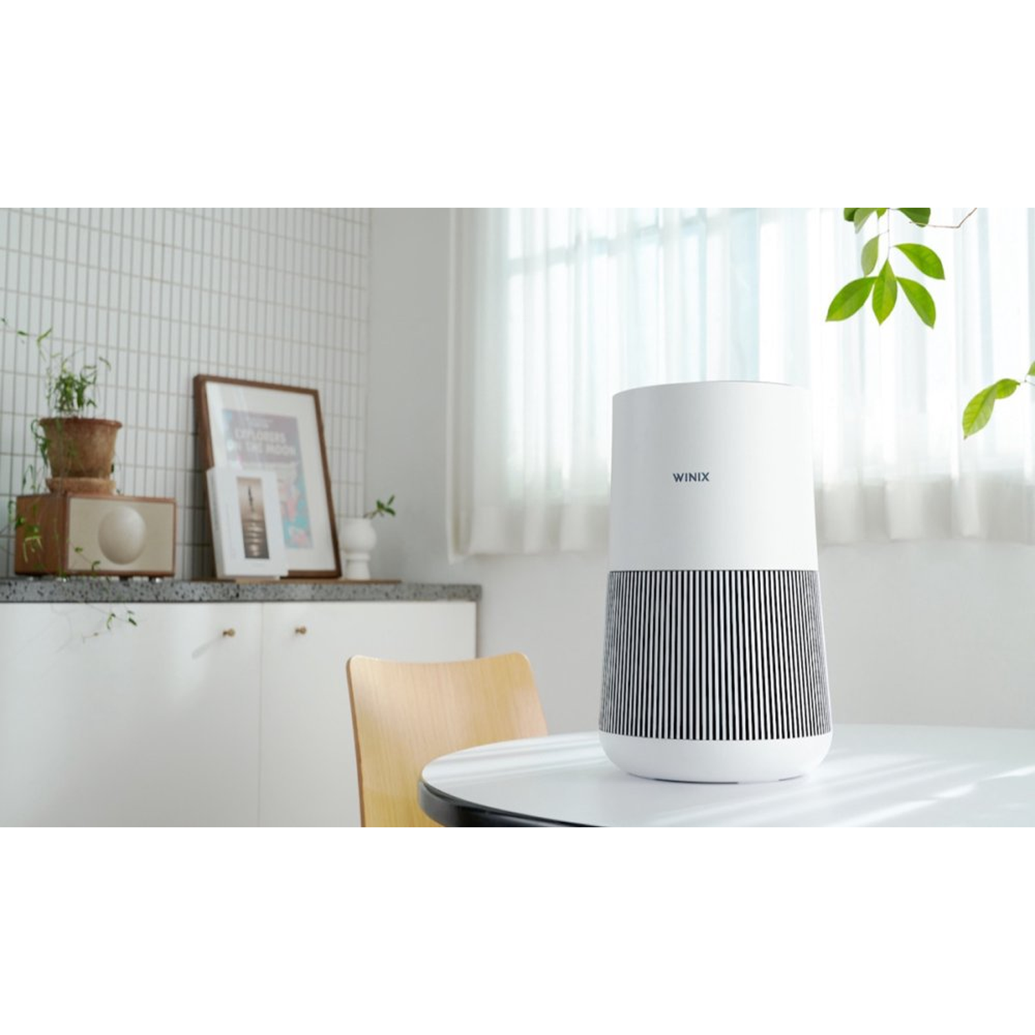 A white air purifier with black stripe pattern sits on a table.