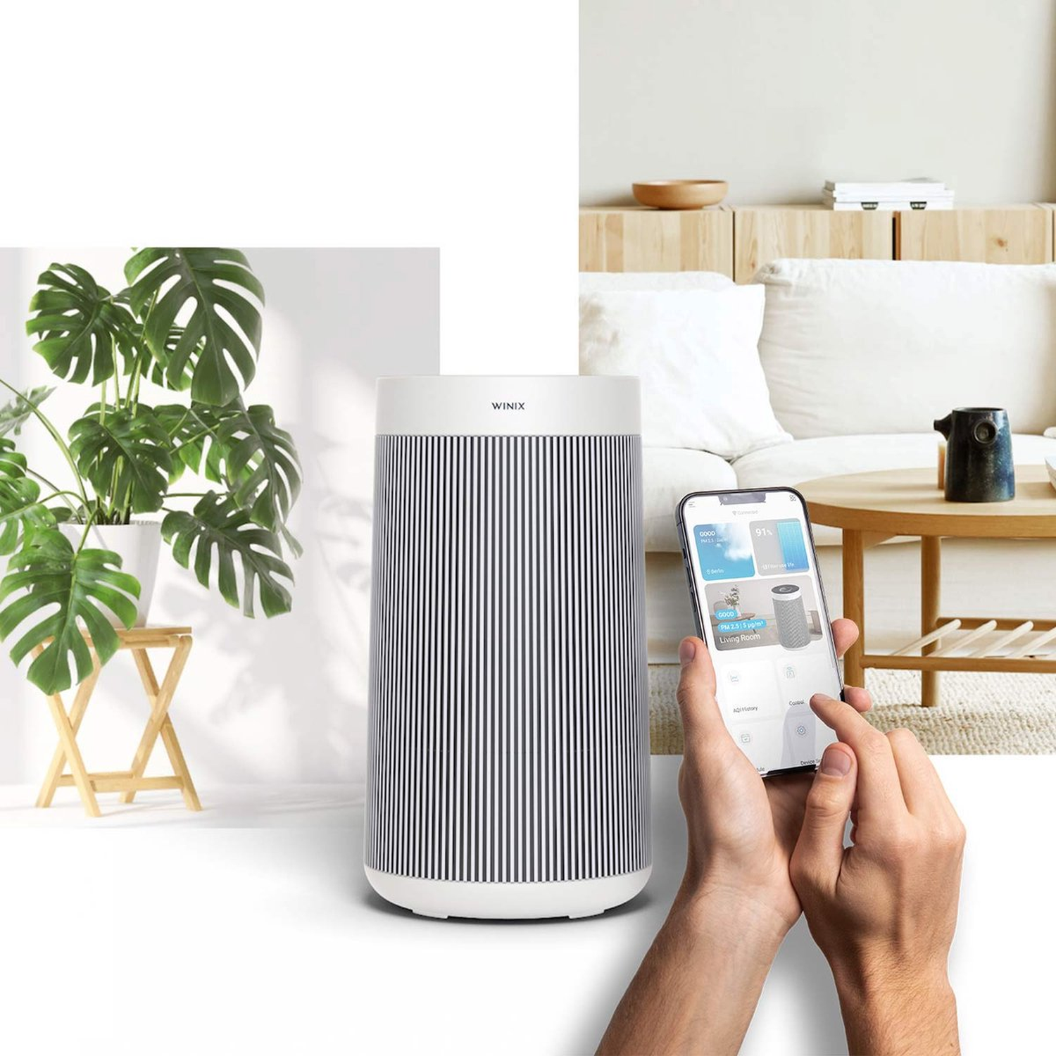 A modern air purifier with a striped design sits next to a potted Monstera plant.