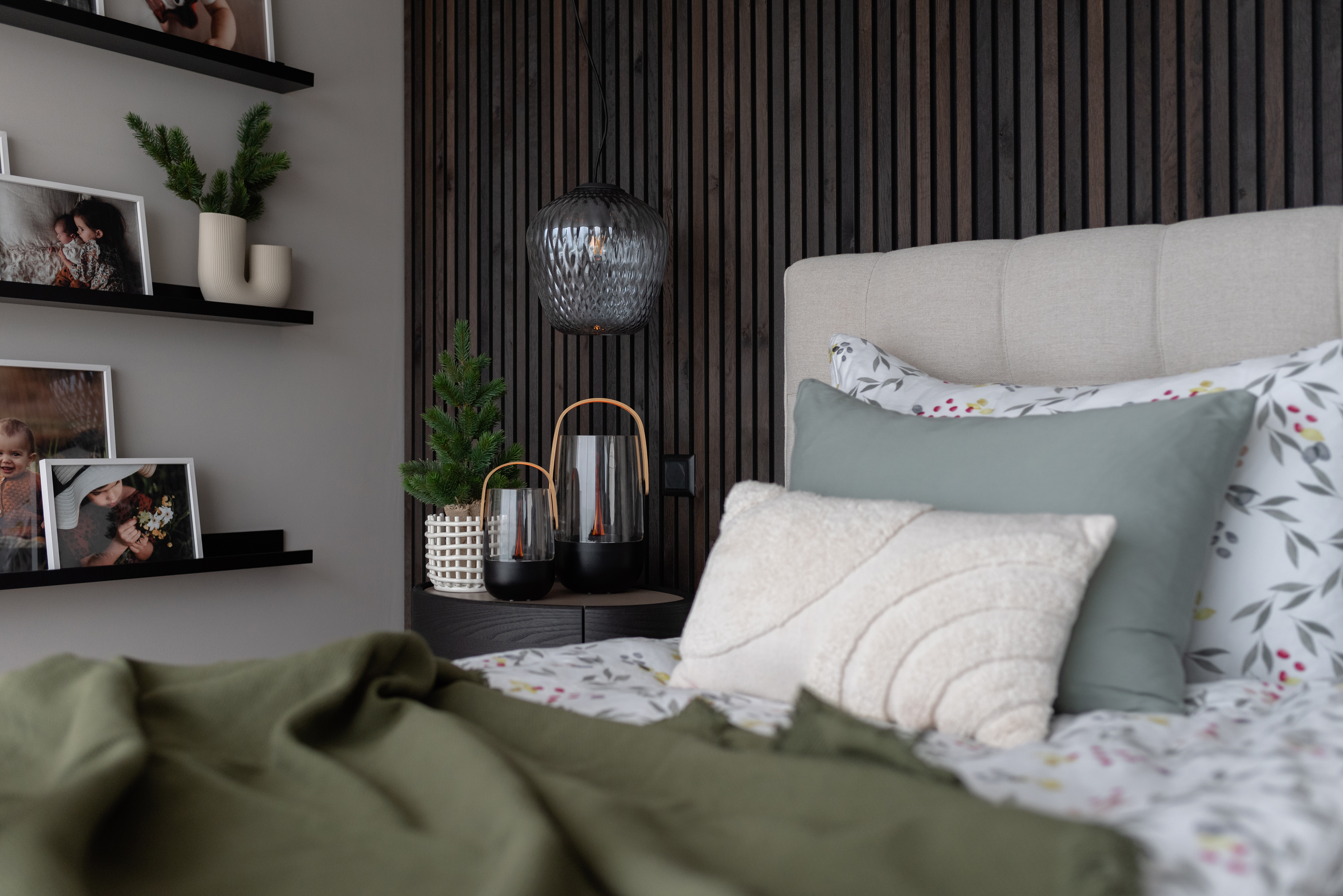 Ein Schlafzimmer mit einem Bett, Kissen und Dekorationen an der Wand.